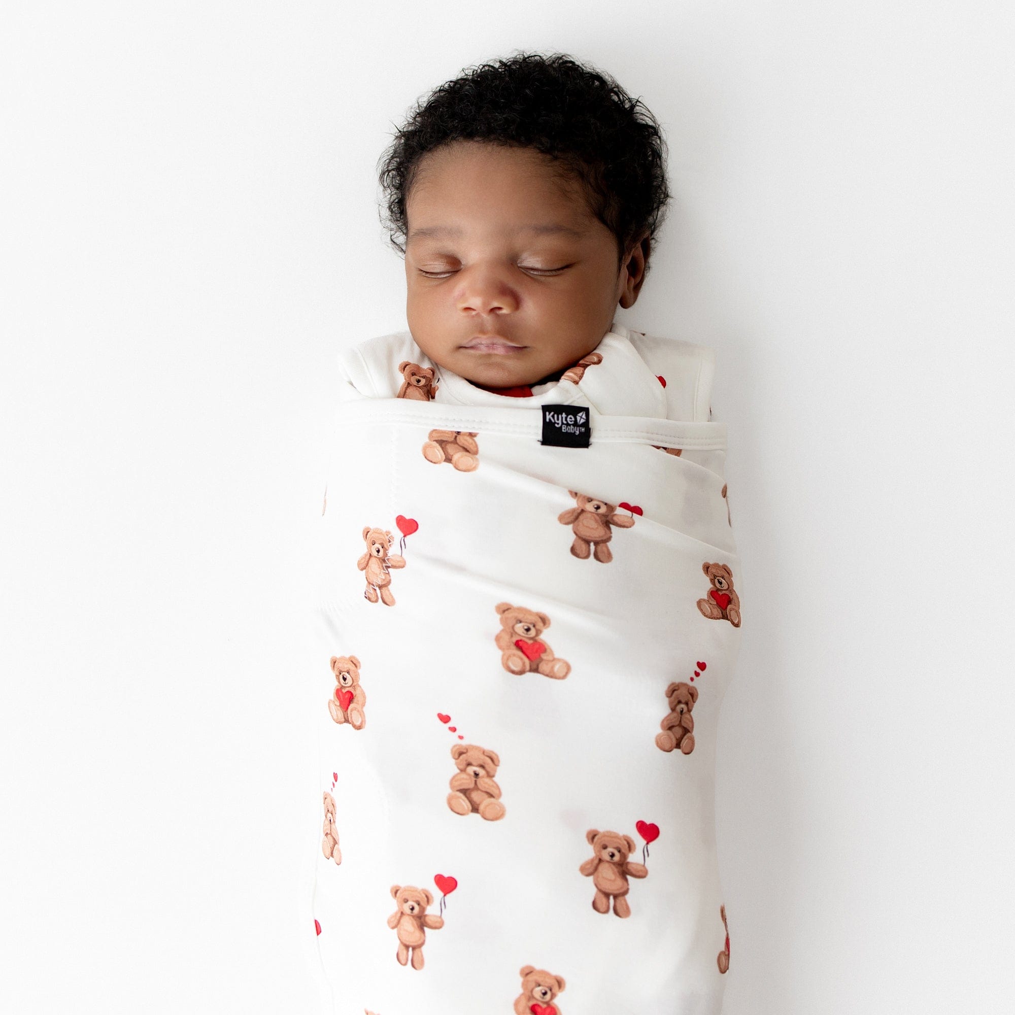Close up of a sleeping newborn swaddled in the Sleep Bag Swaddler in Bear Hearts 1.0