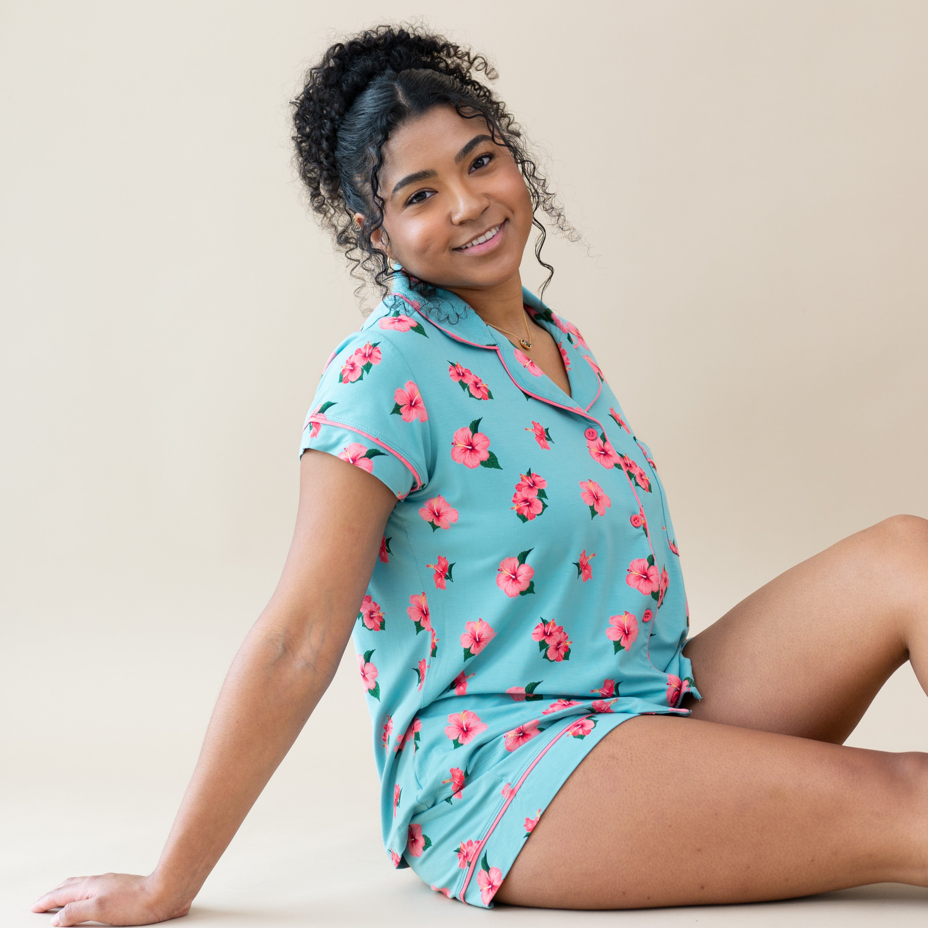 Woman modeling Women’s Short Sleeve Pajama Set in Hibiscus sitting
