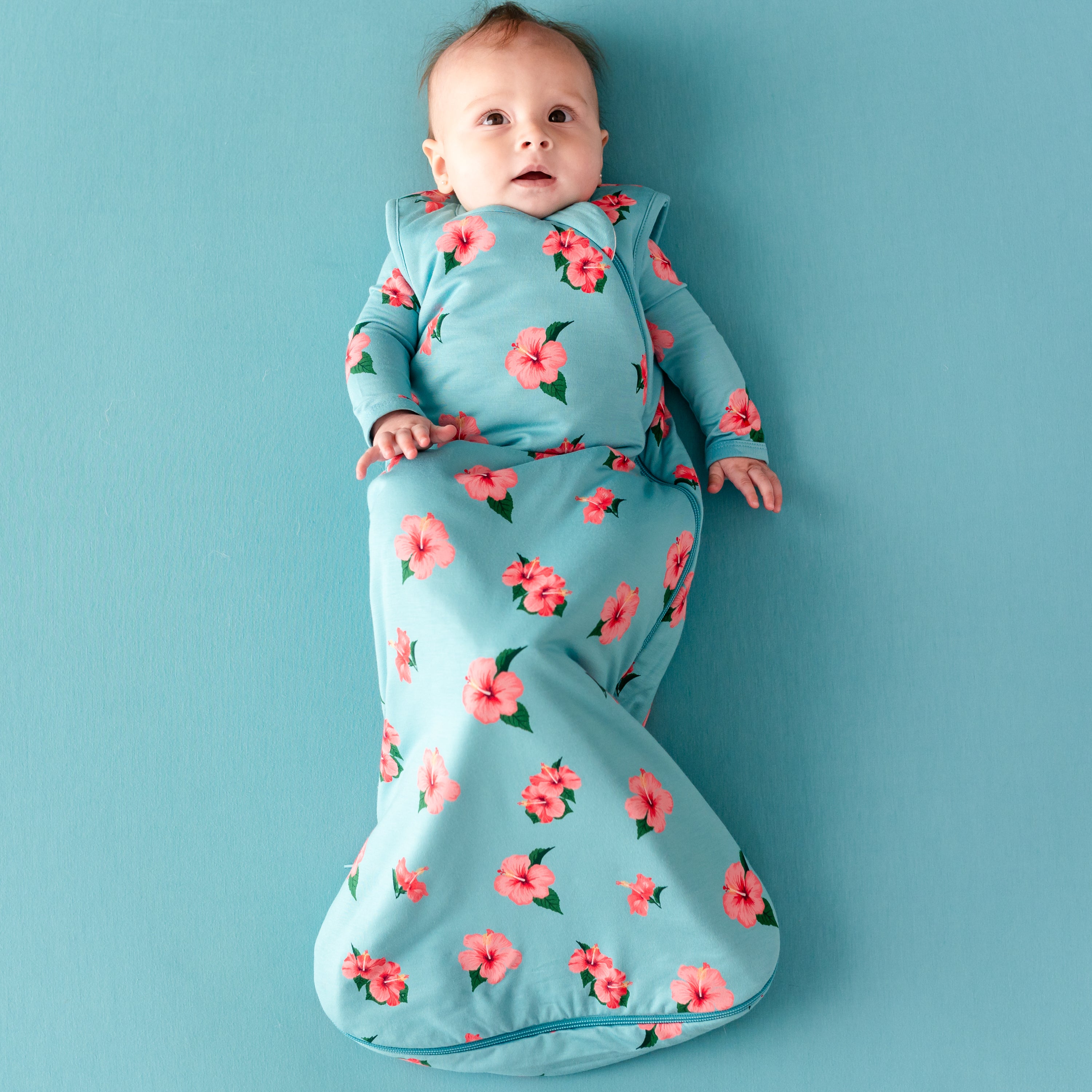 Baby wearing Sleep Bag in Hibiscus 1.0 with Hibiscus long sleeve romper underneath
