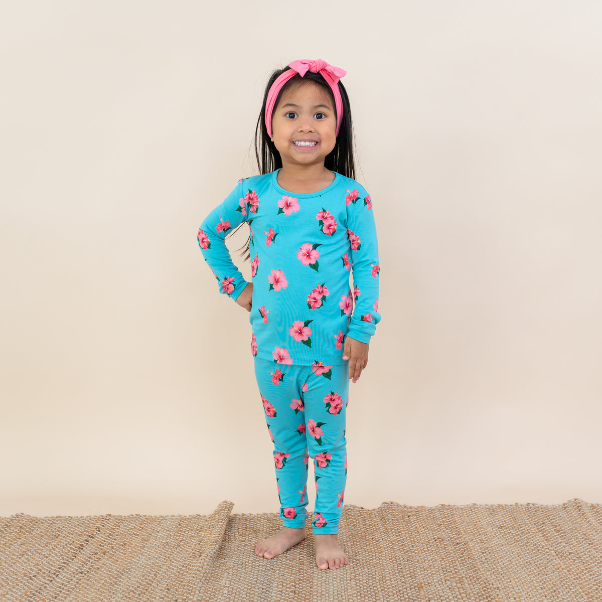 Toddler modeling Kyte Long Sleeve Pajamas in Hibiscus flower print