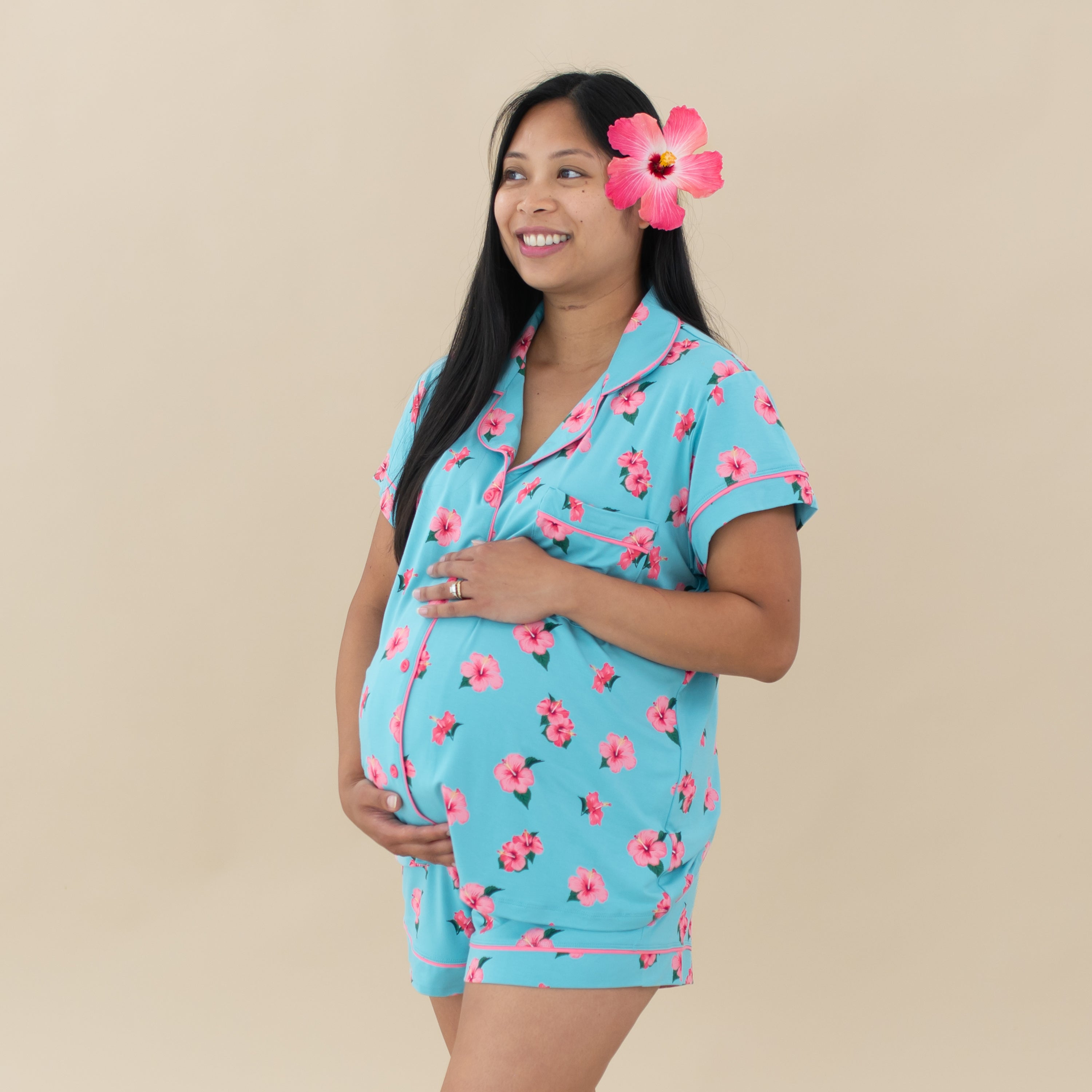 Pregnant mom wearing Women’s Short Sleeve Pajama Set in Hibiscus with a real hibiscus in hair