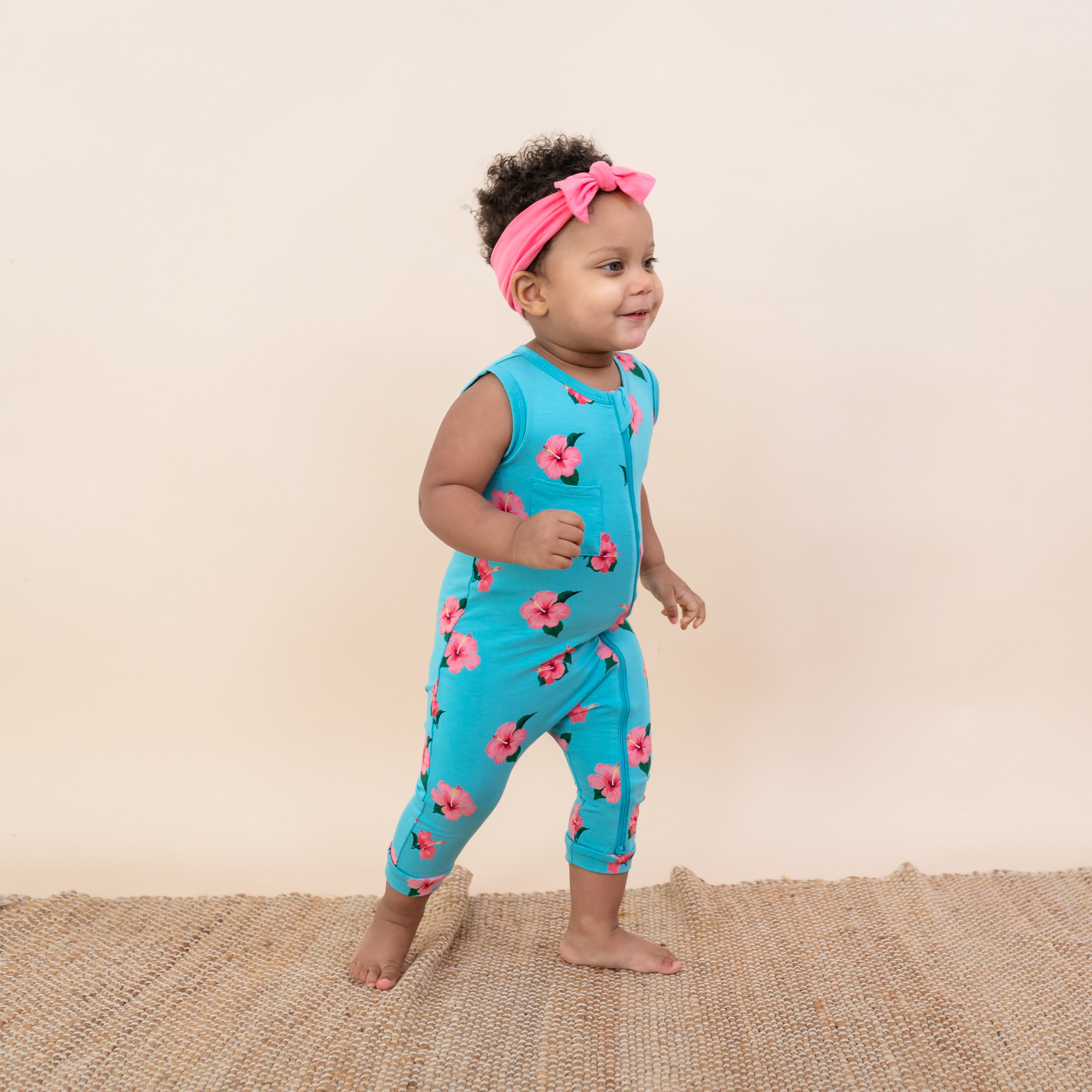 Toddler wearing bamboo Kyte Baby Sleeveless Zippered Romper in Hibiscus