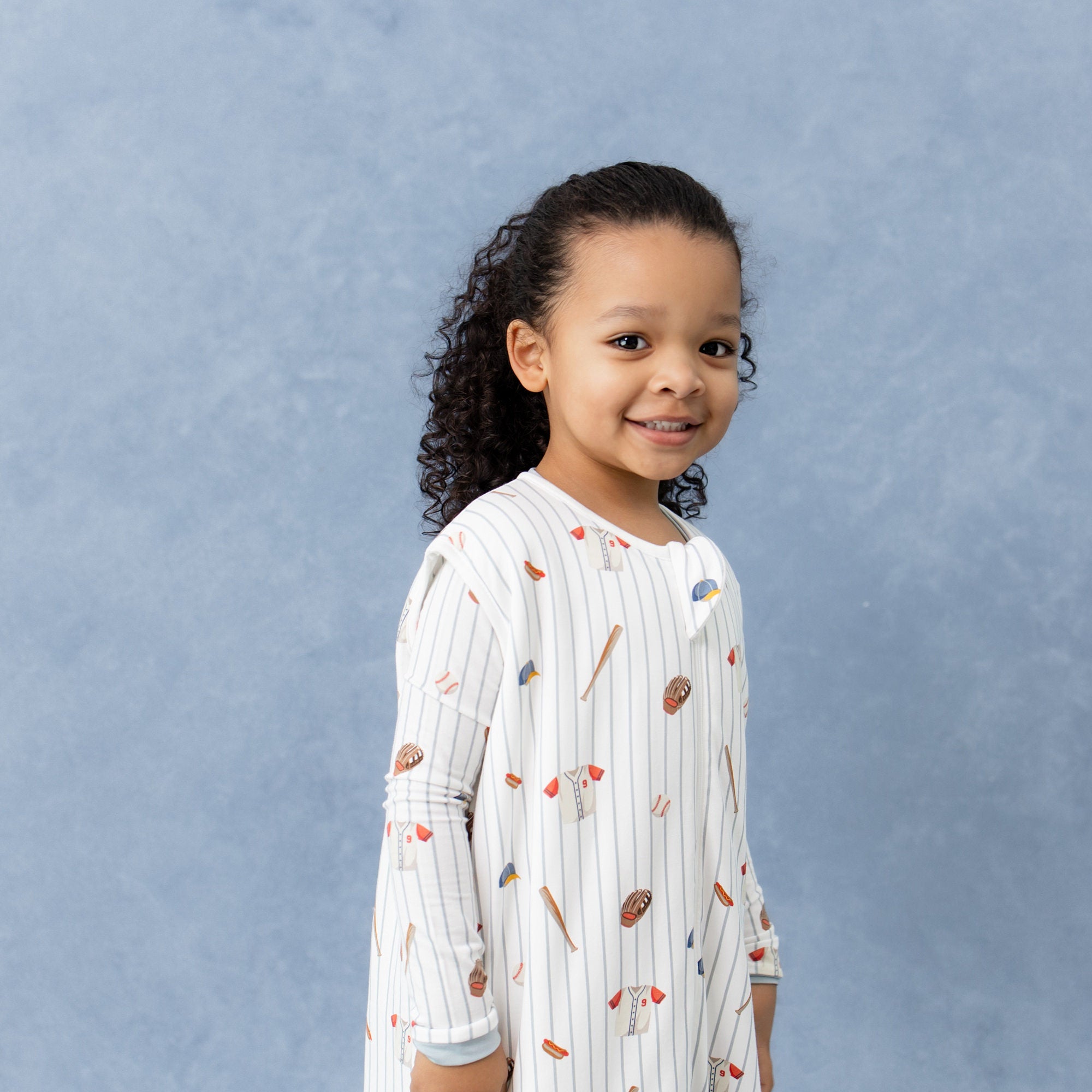 Close up of young girl wearing the Sleep Bag Walker in Home Run 1.0 with matching long sleeve pajamas on