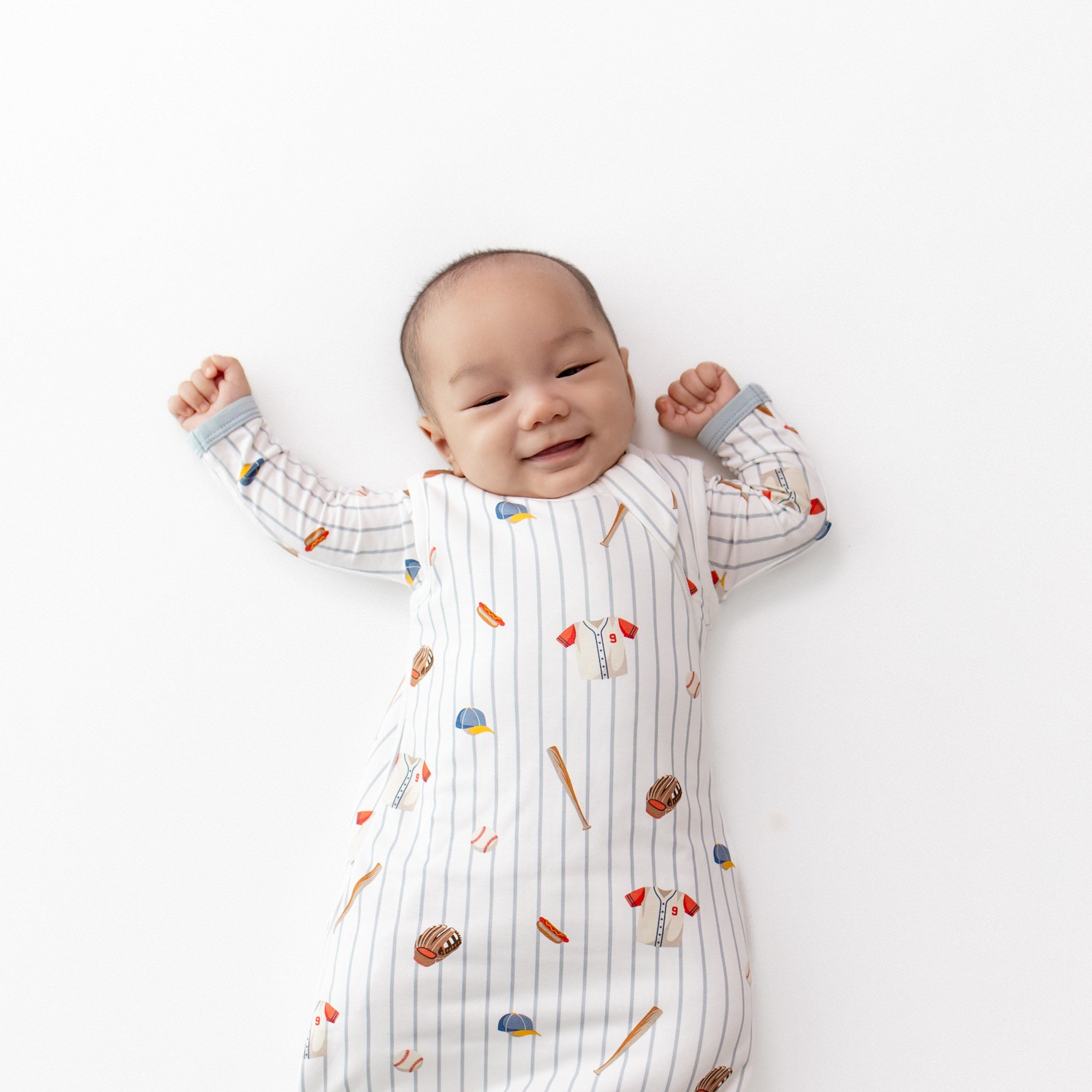 Close up of an infant wearing the Sleep Bag in Home Run 1.0 with a matching romper