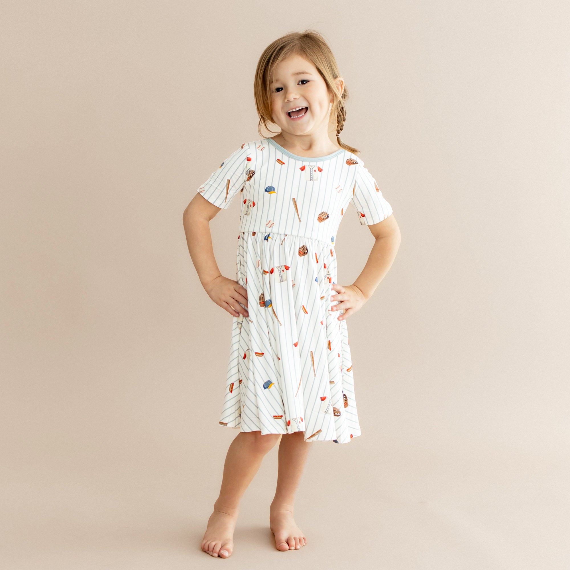 Young girl posing wearing the Twirl Dress in Home Run