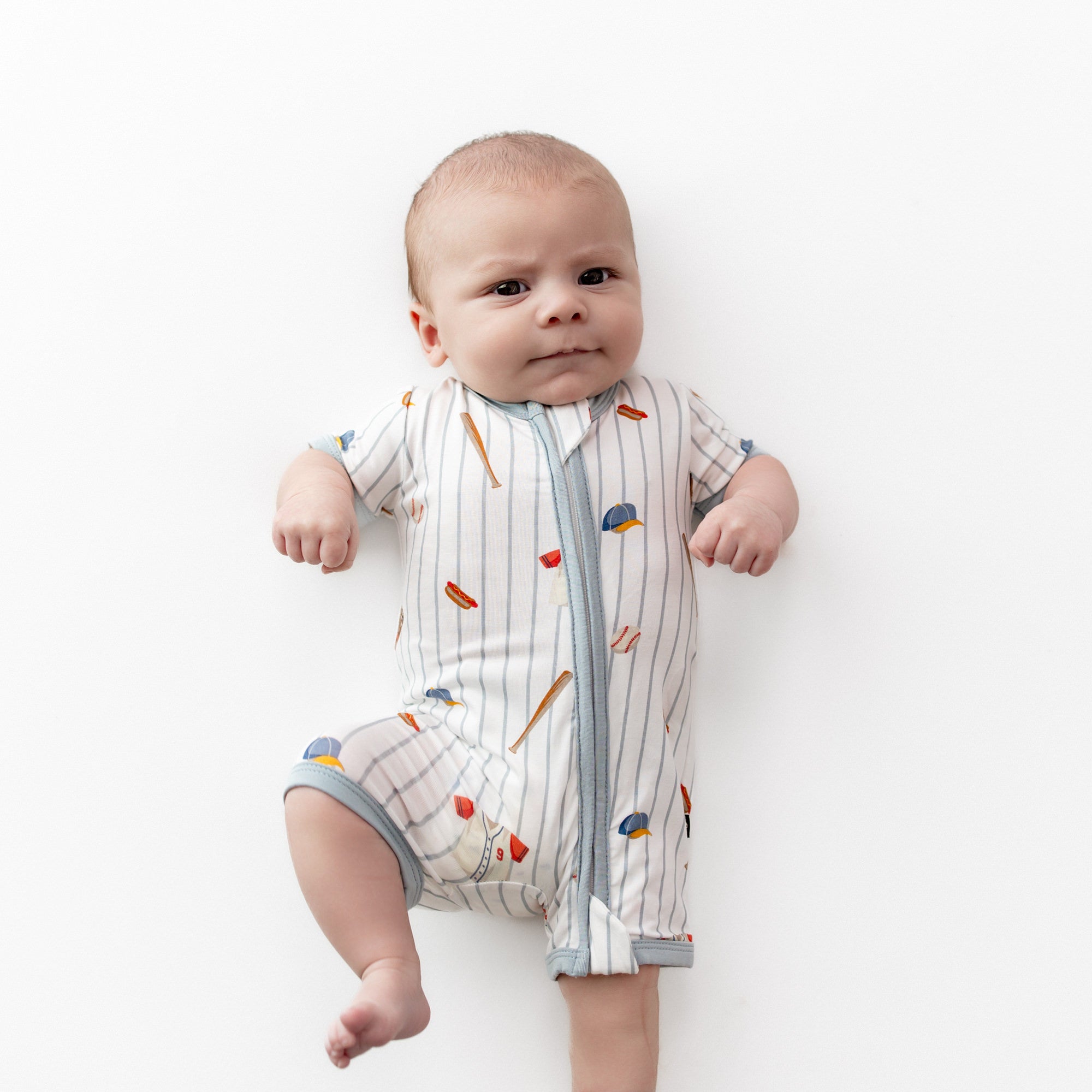 Close up of infant wearing the Zipper Shortall Romper in Home Run
