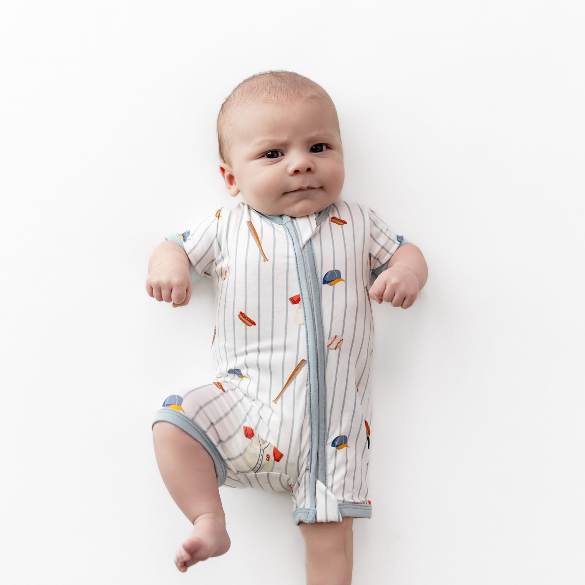 Close up of infant wearing the Zipper Shortall Romper in Home Run