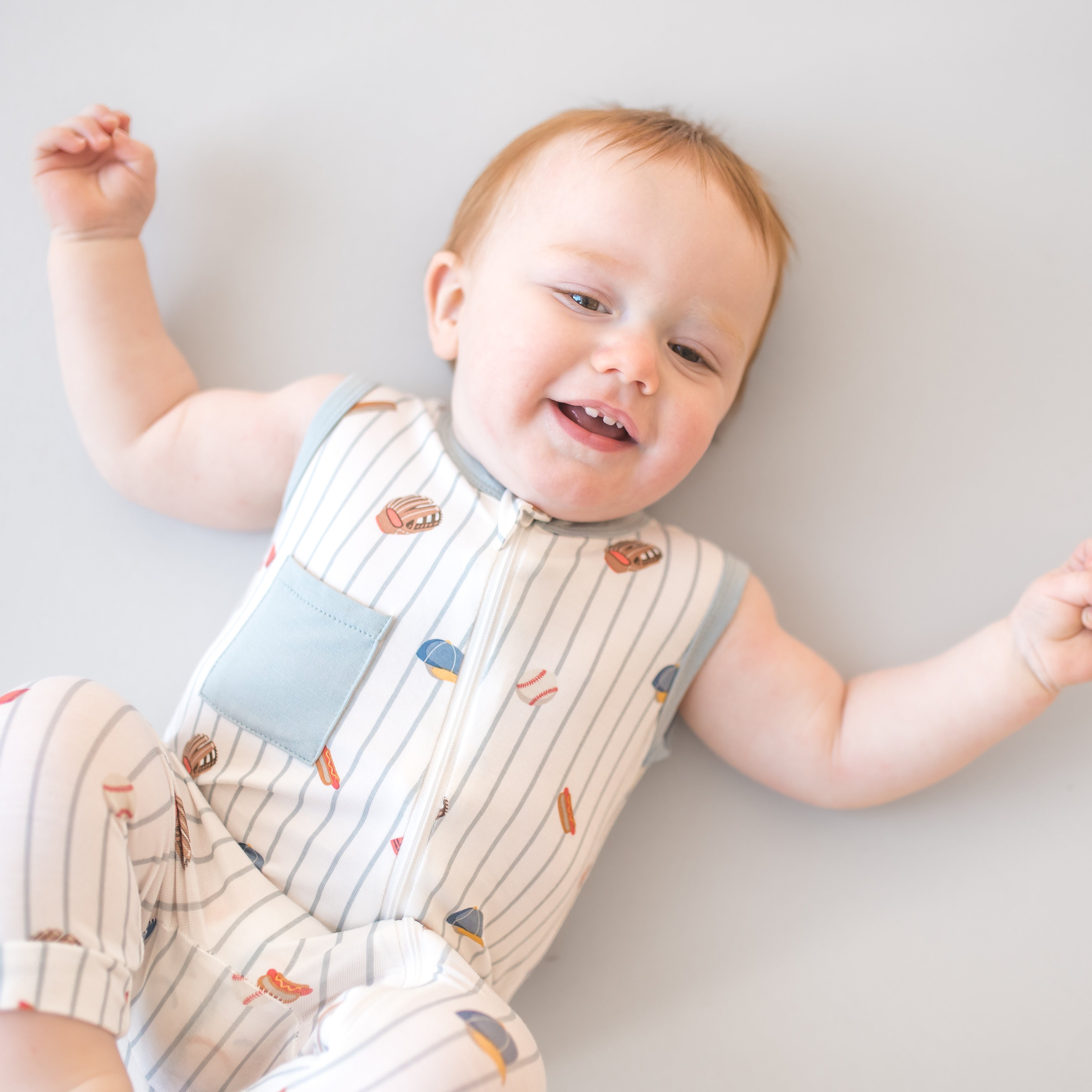 Close up of toddler wearing the Zippered Sleeveless Romper in Home Run