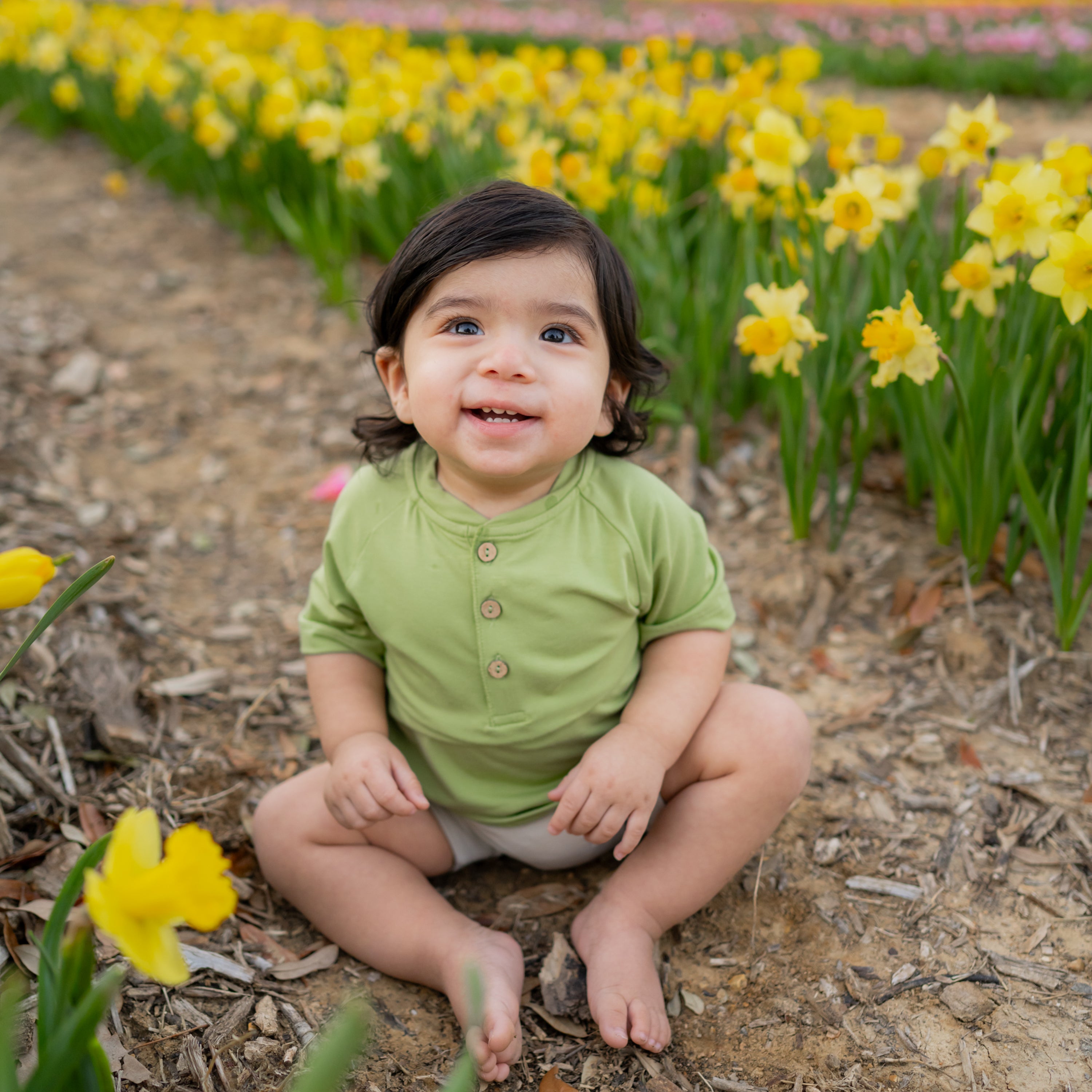 Baby smiling in Short Sleeve Toddler Henley Tee in Honu