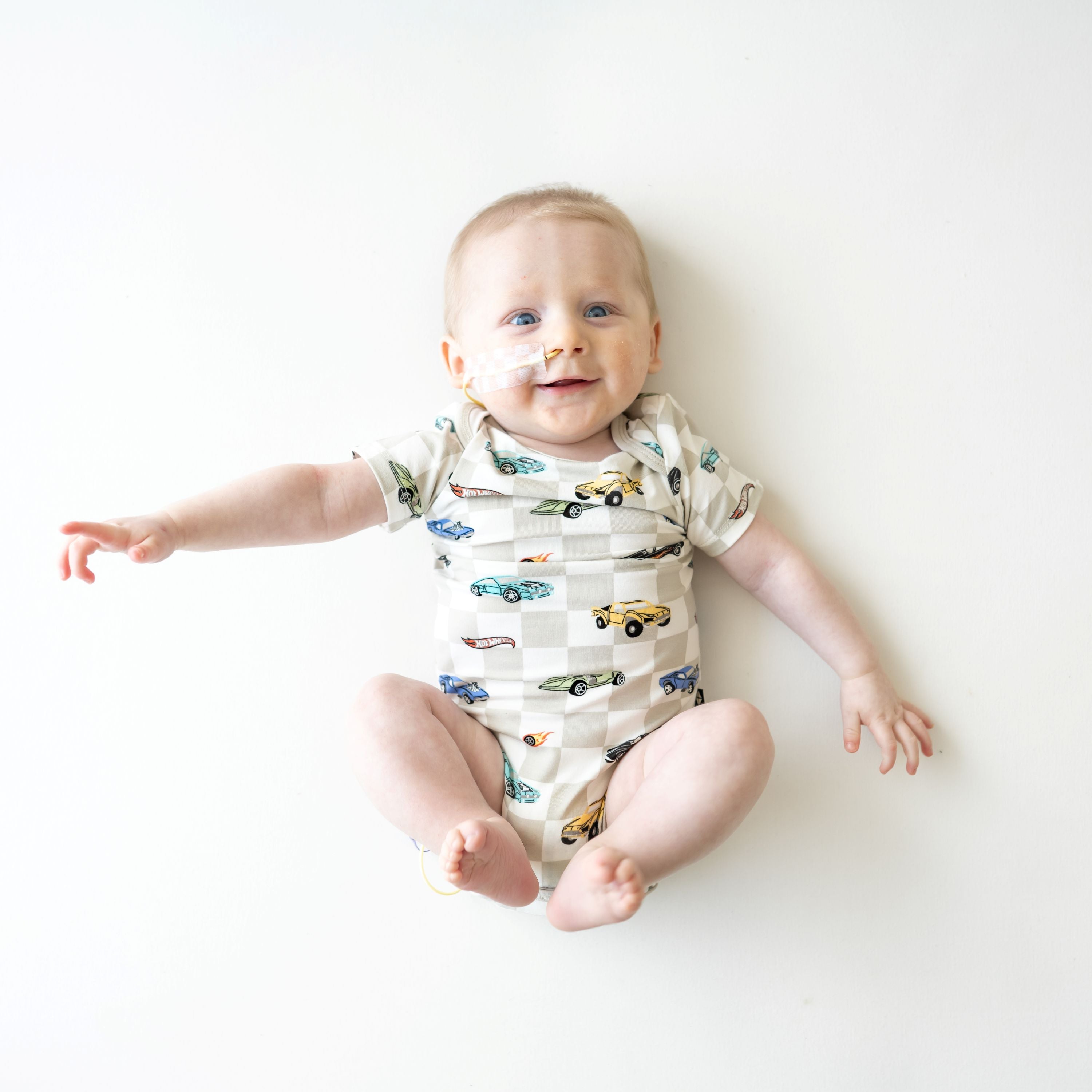 Infant laying with his feet in the air wearing the Bodysuit in Fast and Fierce