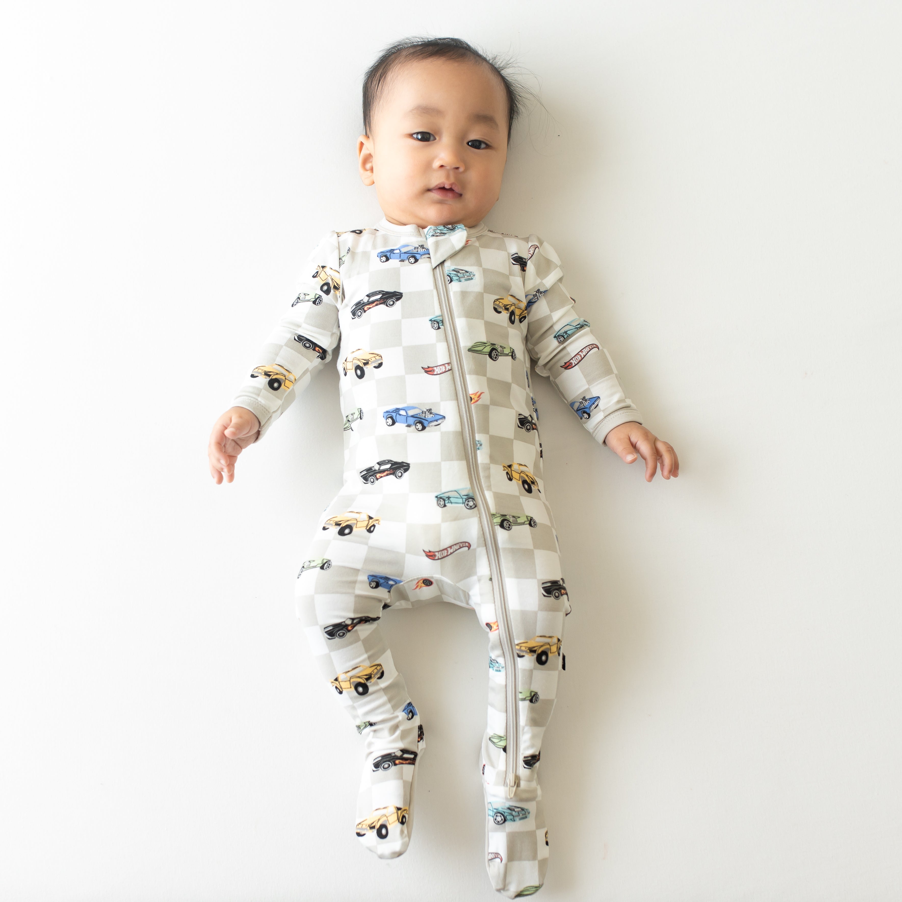 Infant laying down wearing the Zippered Footie in Fast and Fierce