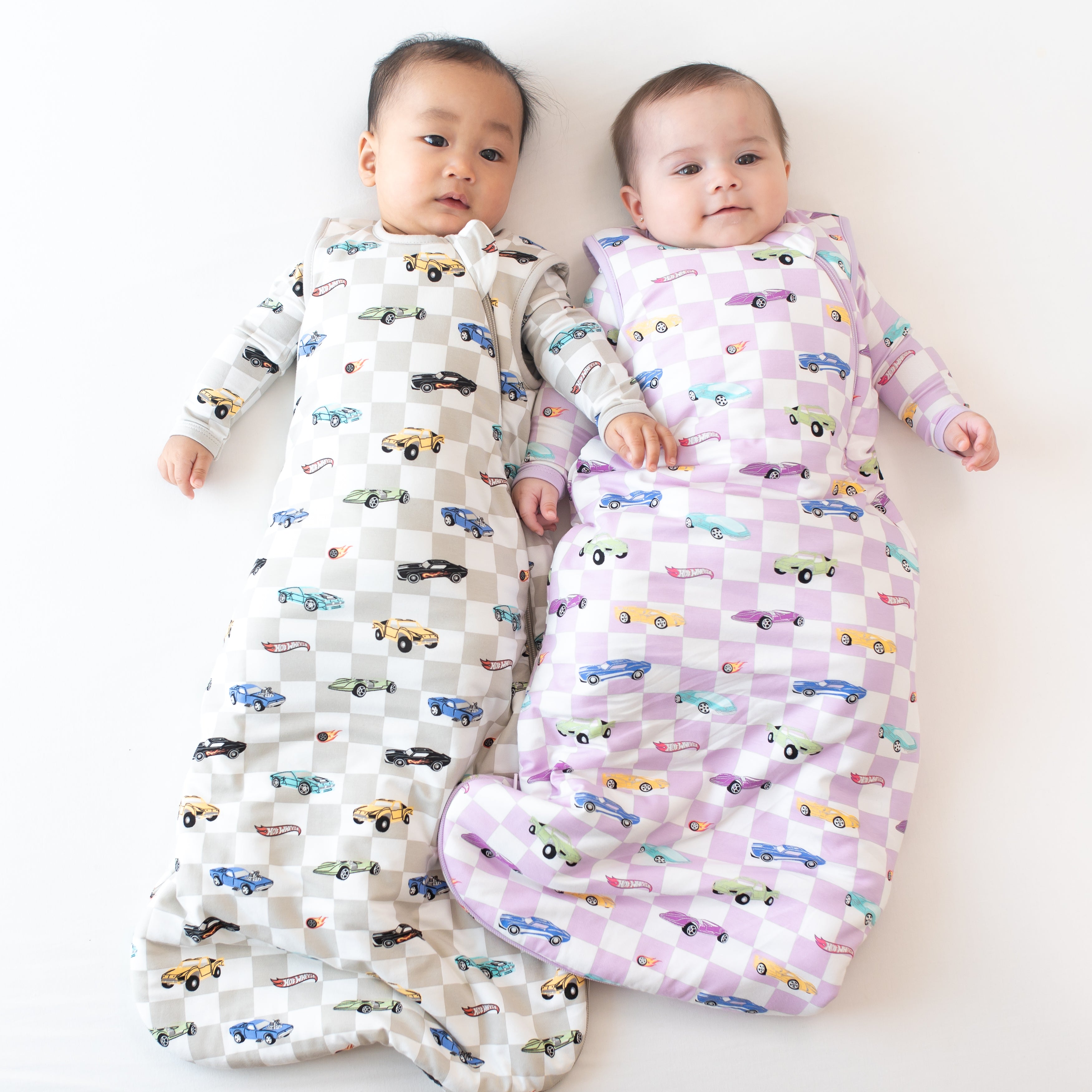 Two babies wearing 1.0 Hot Wheels Sleep Bags in Fast and Fierce and Sparkles and Speed