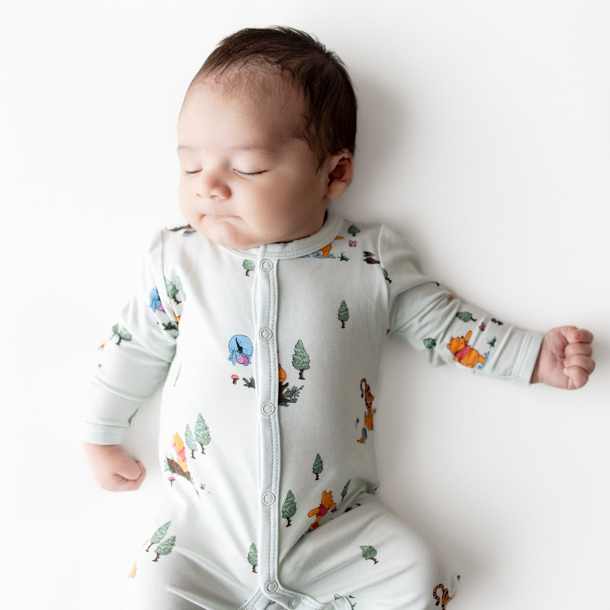 Close up of sleeping newborn wearing the Romper in Winnie the Pooh Hundred Acre Wood