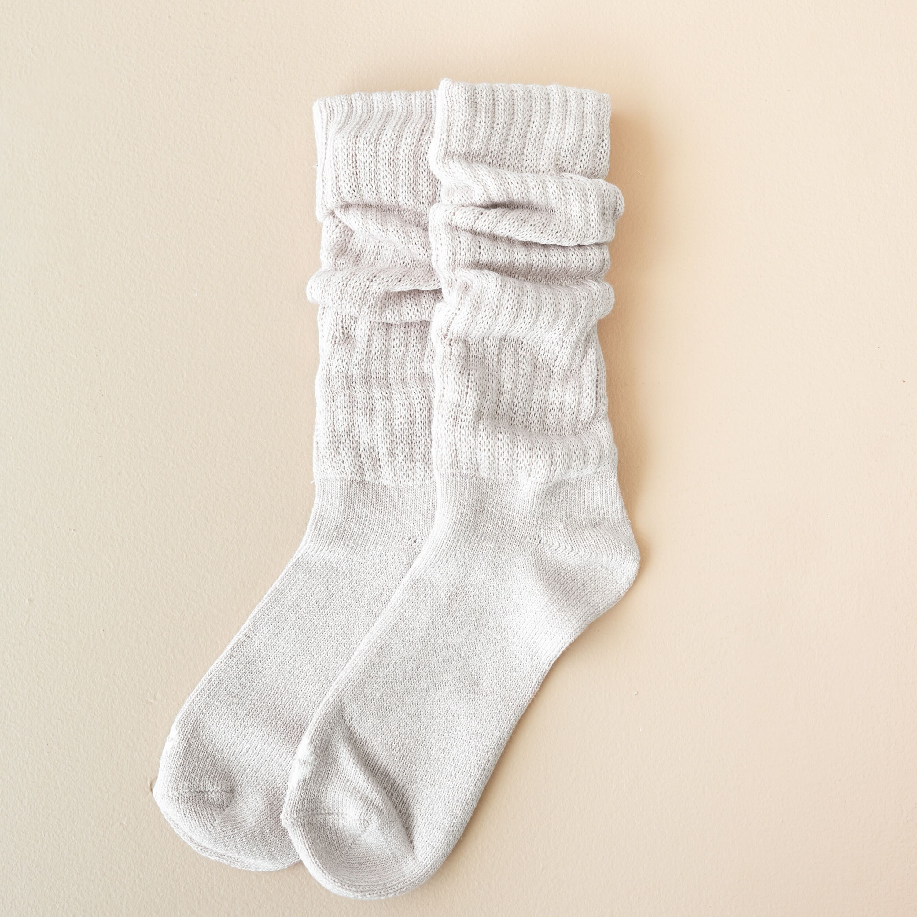 Adult Scrunch Socks in Oat shown scrunched while laid out flat on a light neutral background