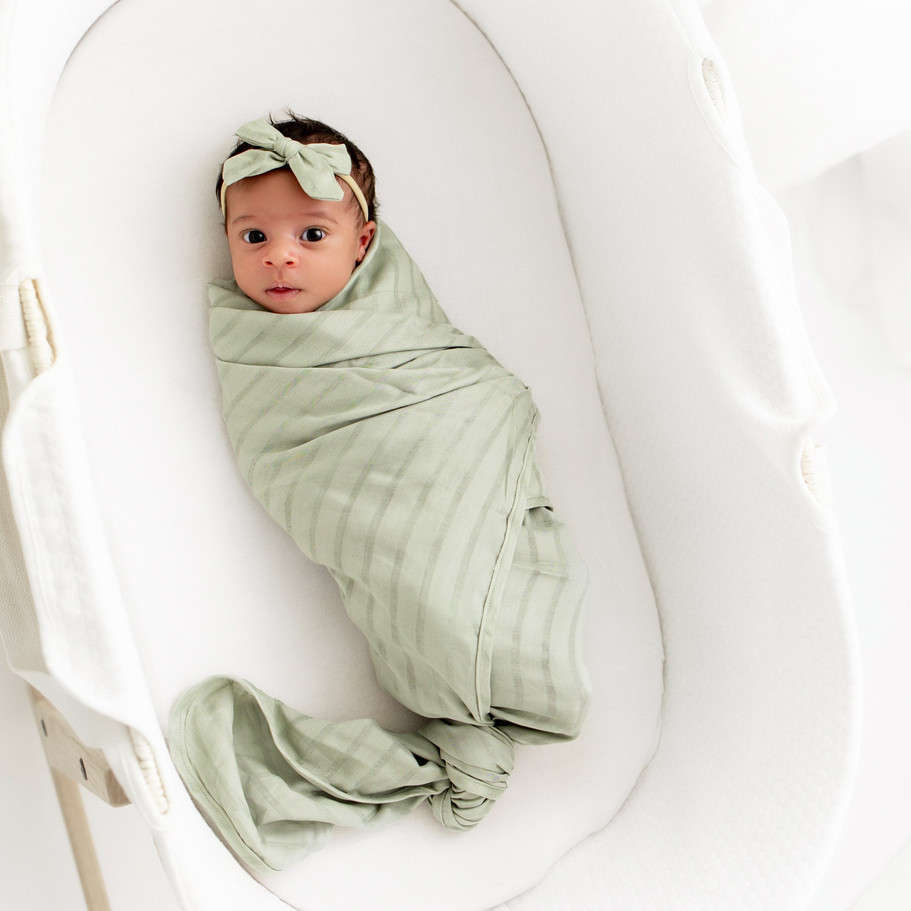 Baby swaddled in Bamboo Muslin Swaddle Blanket in Jojoba Green