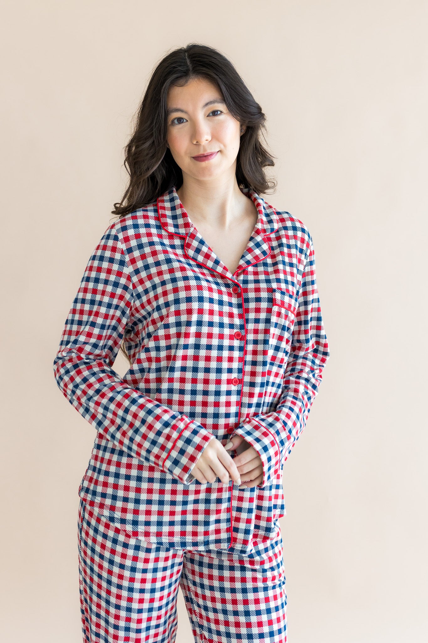 Model wearing Long-Sleeved Women's Pajama Set in red blue and white Patriotic Gingham check print on a beige background
