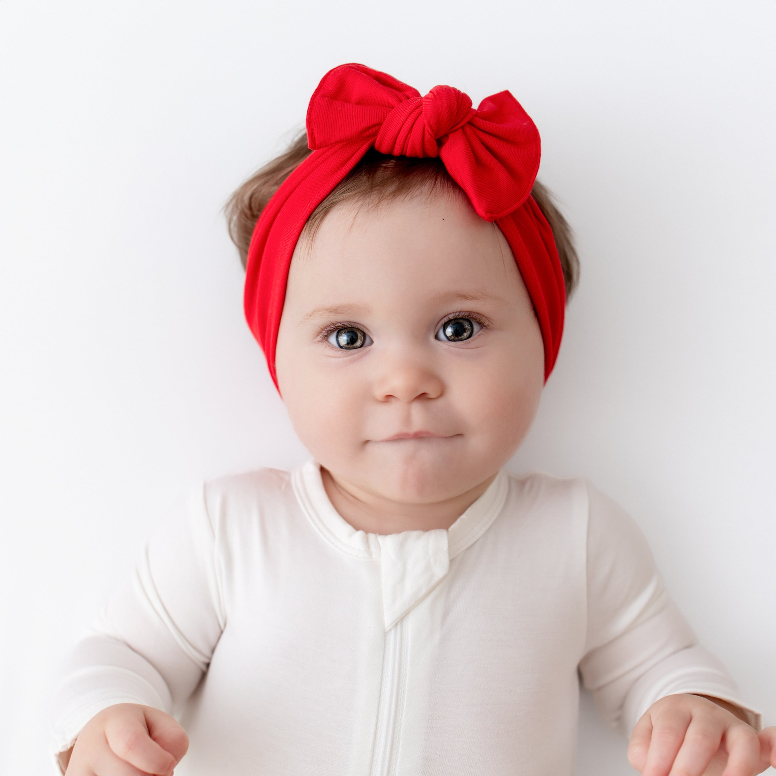 Baby wearing Knotted Bow Headband in Cardinal