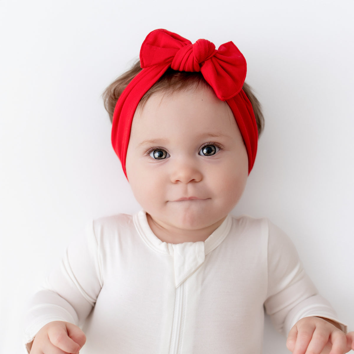 Baby wearing Knotted Bow Headband in Cardinal