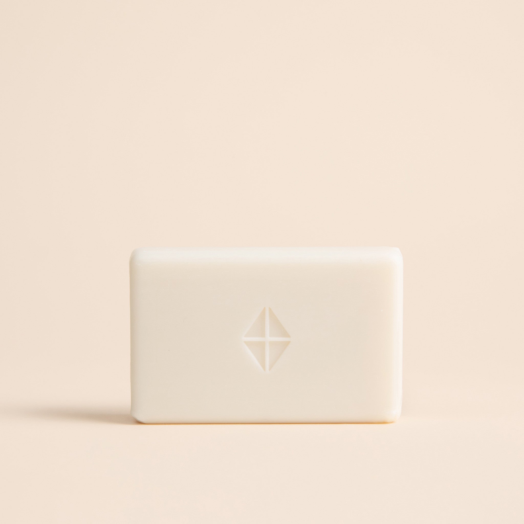White bar of soap with a logo on a beige background