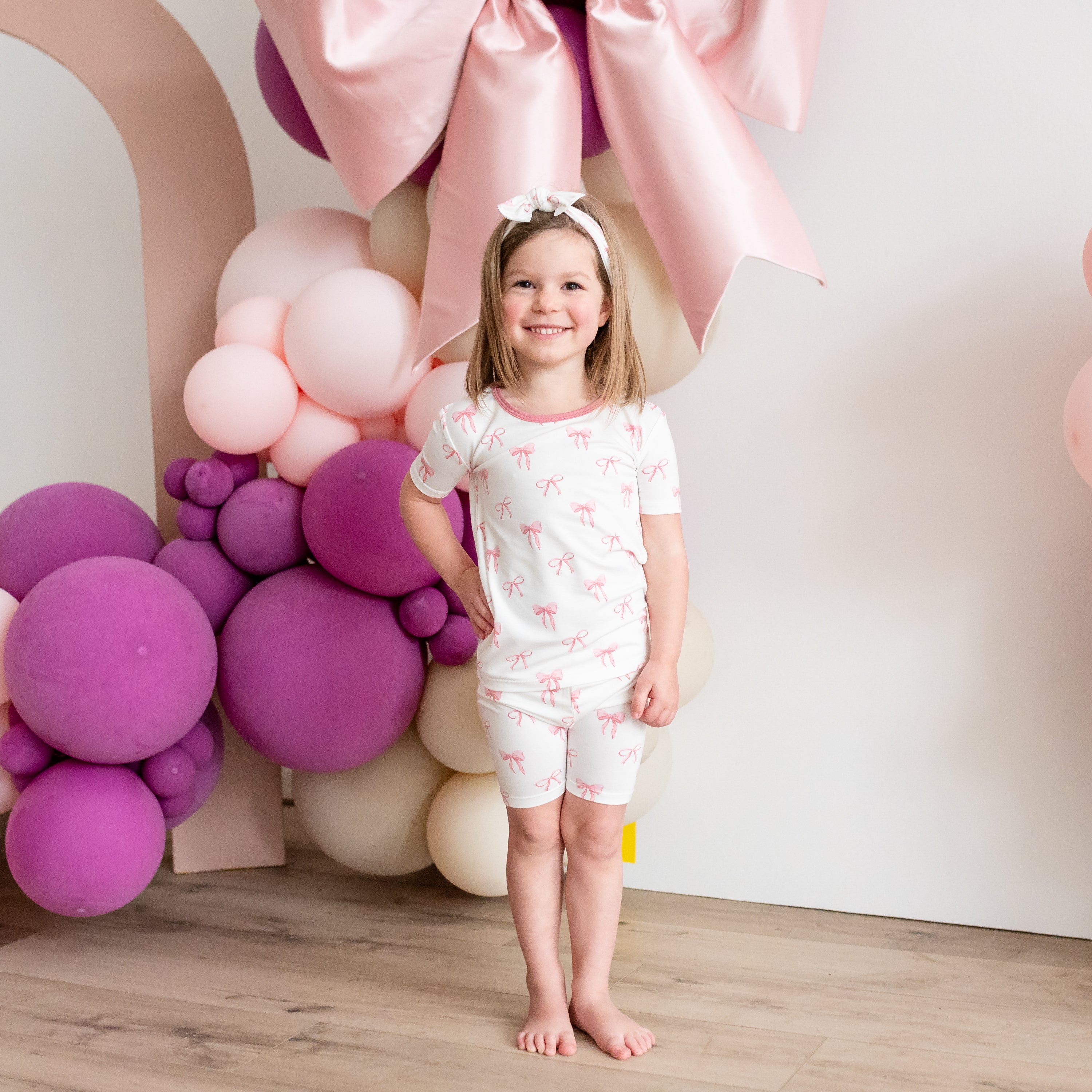 Child wearing Short Sleeve Kids Pajamas in Bow pink