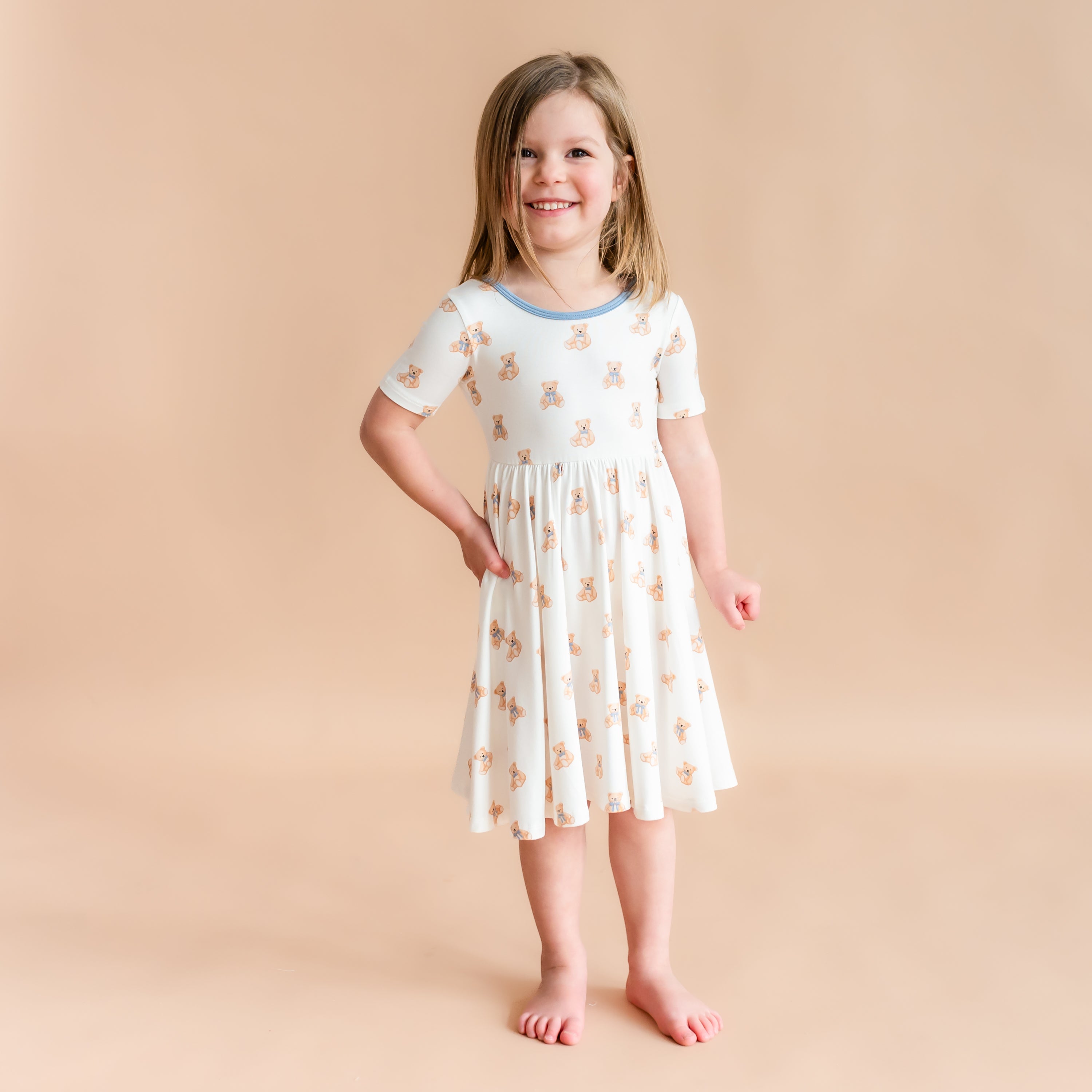 Girl wearing Twirl Dress in Teddy Bear with hand on hip