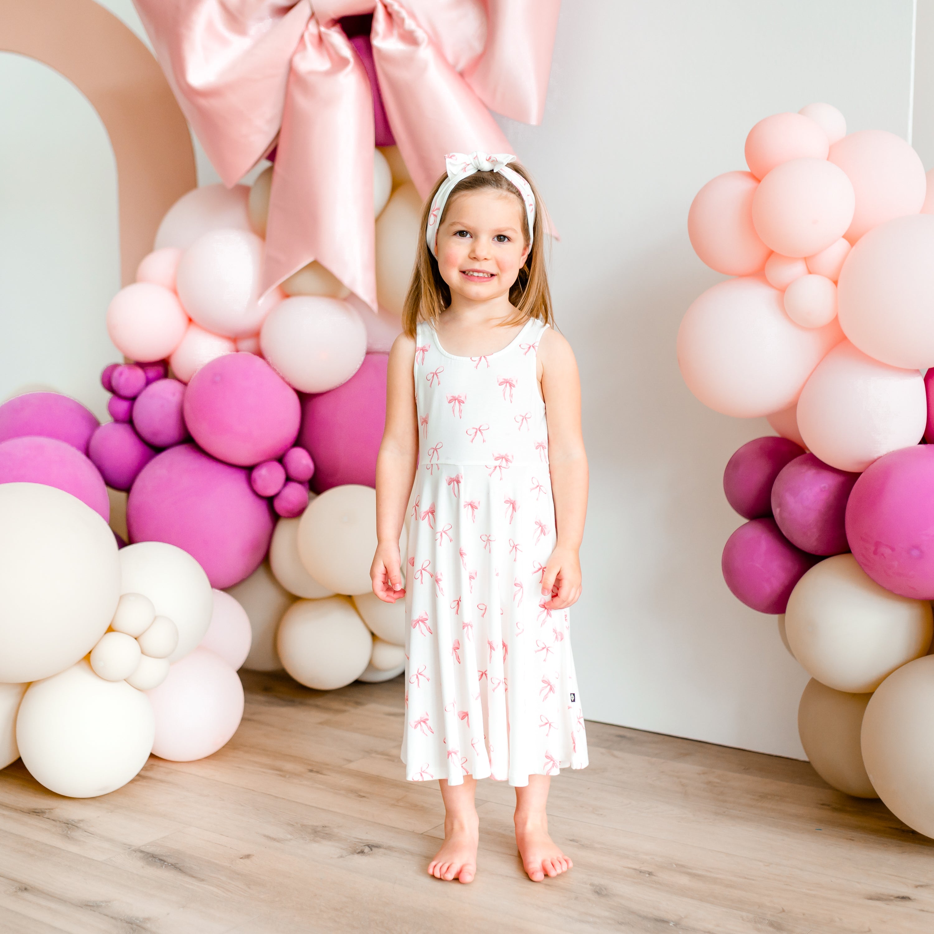 Child modeling Tank Twirl Dress in Bow with a balloon backdrop