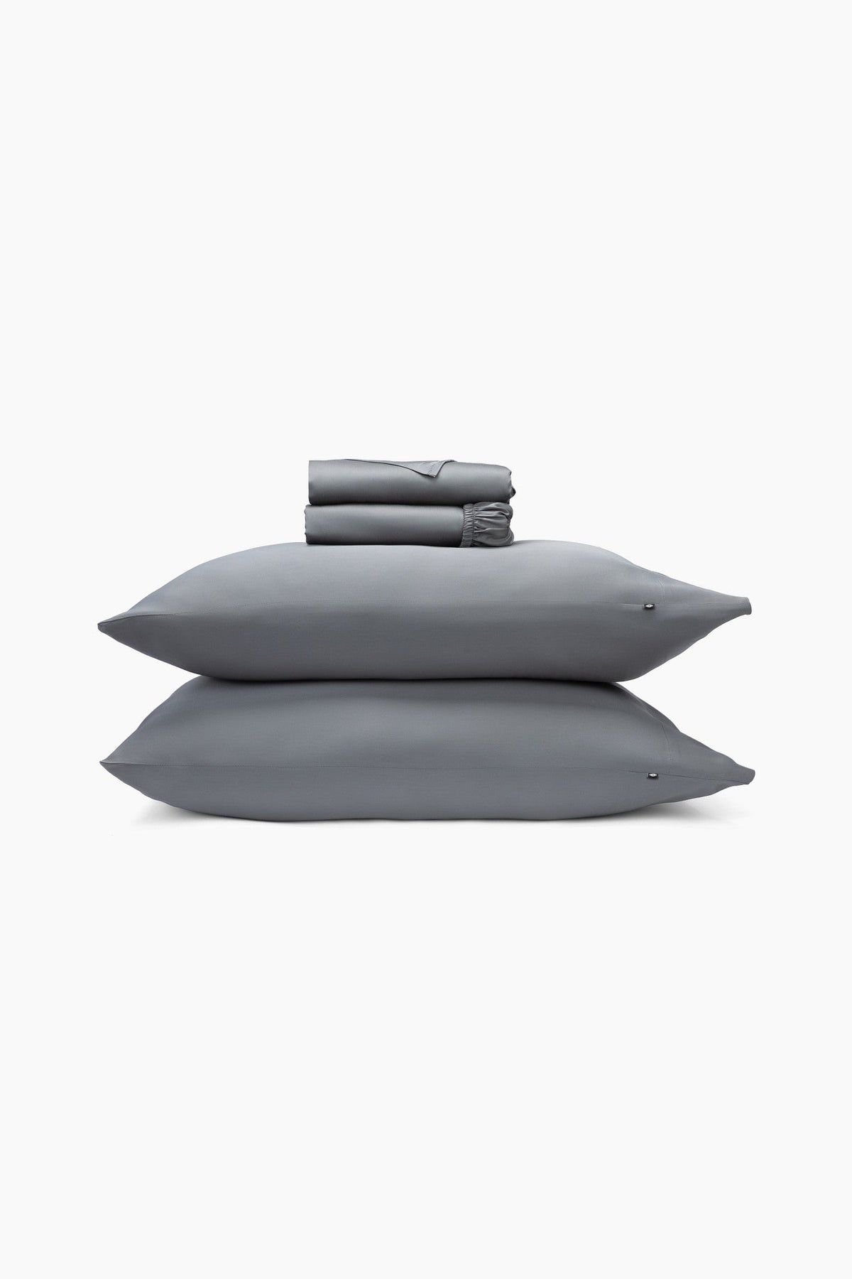 Gray bedding set with two pillows and a folded sheets on a white background