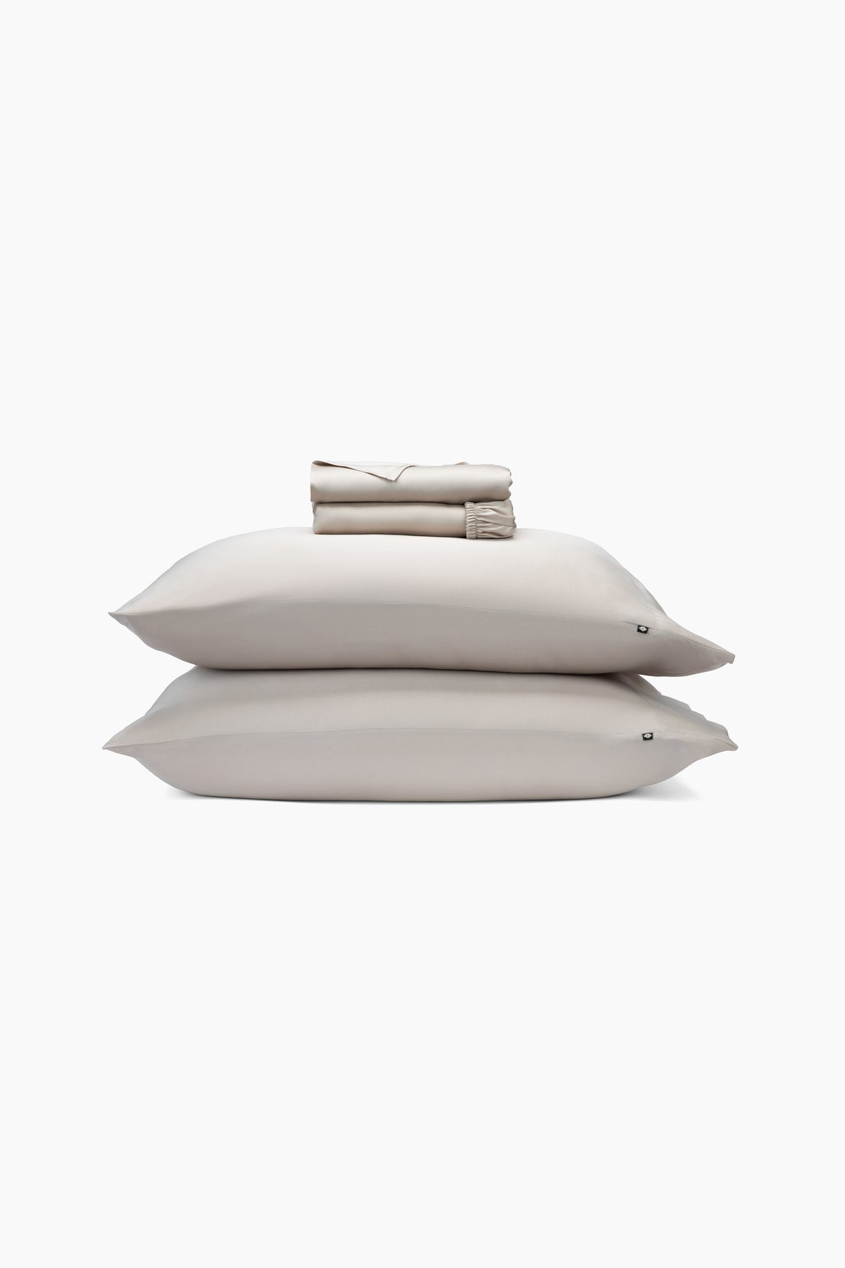 Beige pillows and folded sheets on a white background