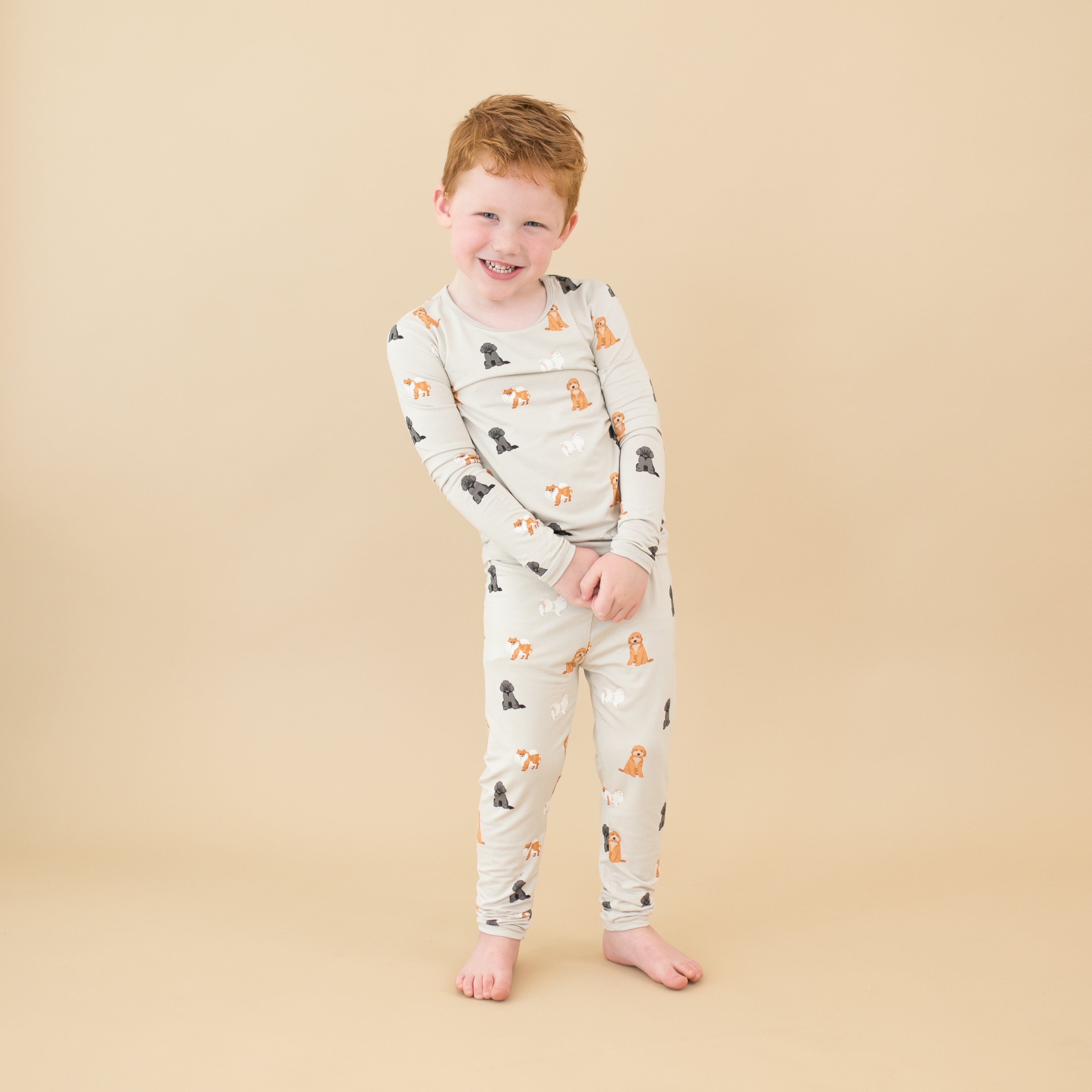 Toddler smiling modeling Long Sleeve Pajamas in Fluffy Dog