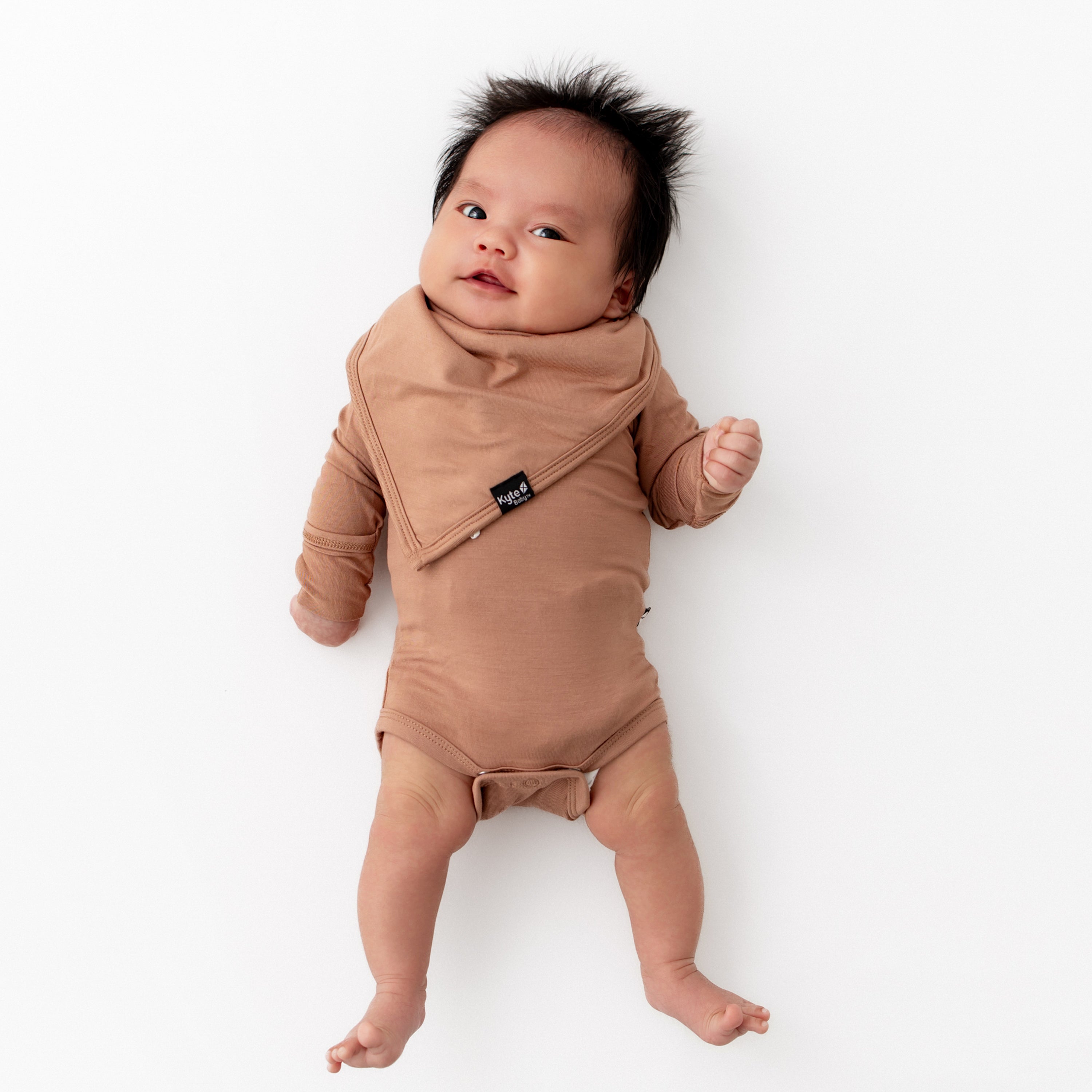 Baby wearing long sleeve brown onesie with Bib in Latte