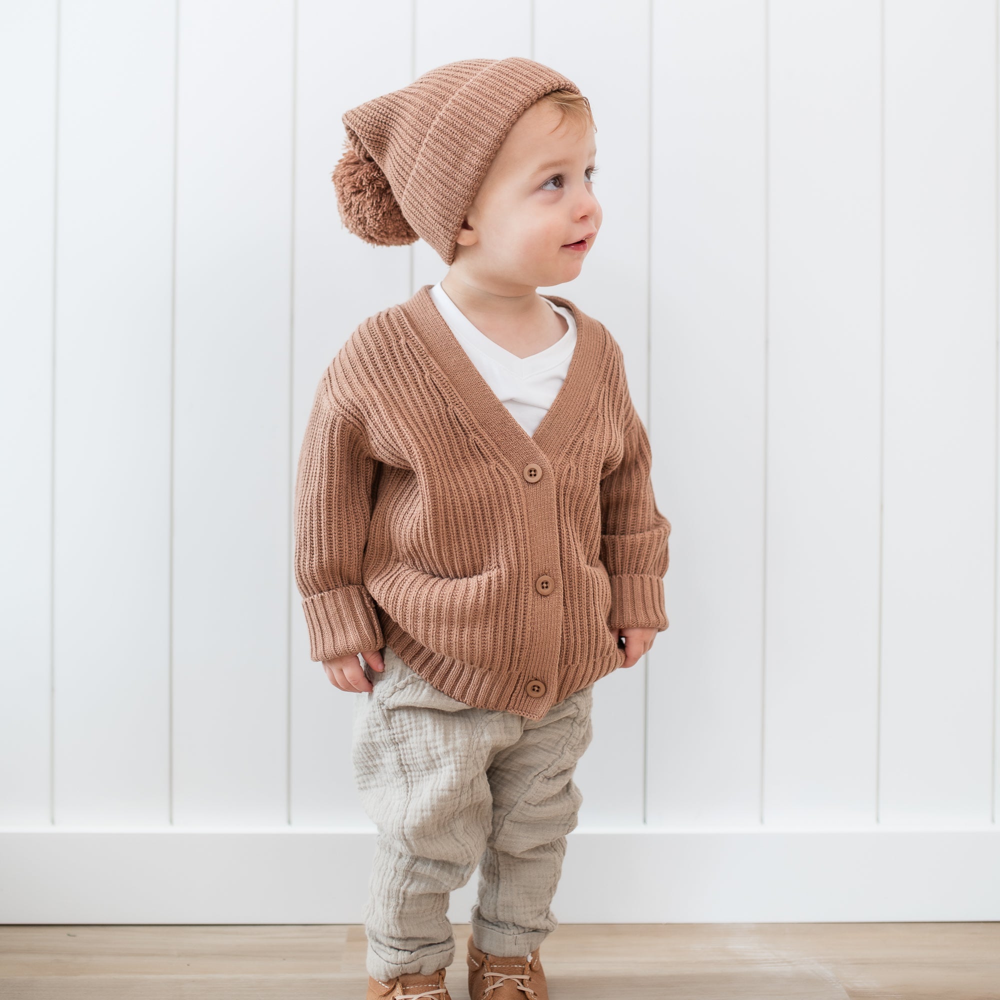Toddler wearing the Chunky Knit Oversized Cardigan in Latte with the matching Chunky Knit Pom beanie