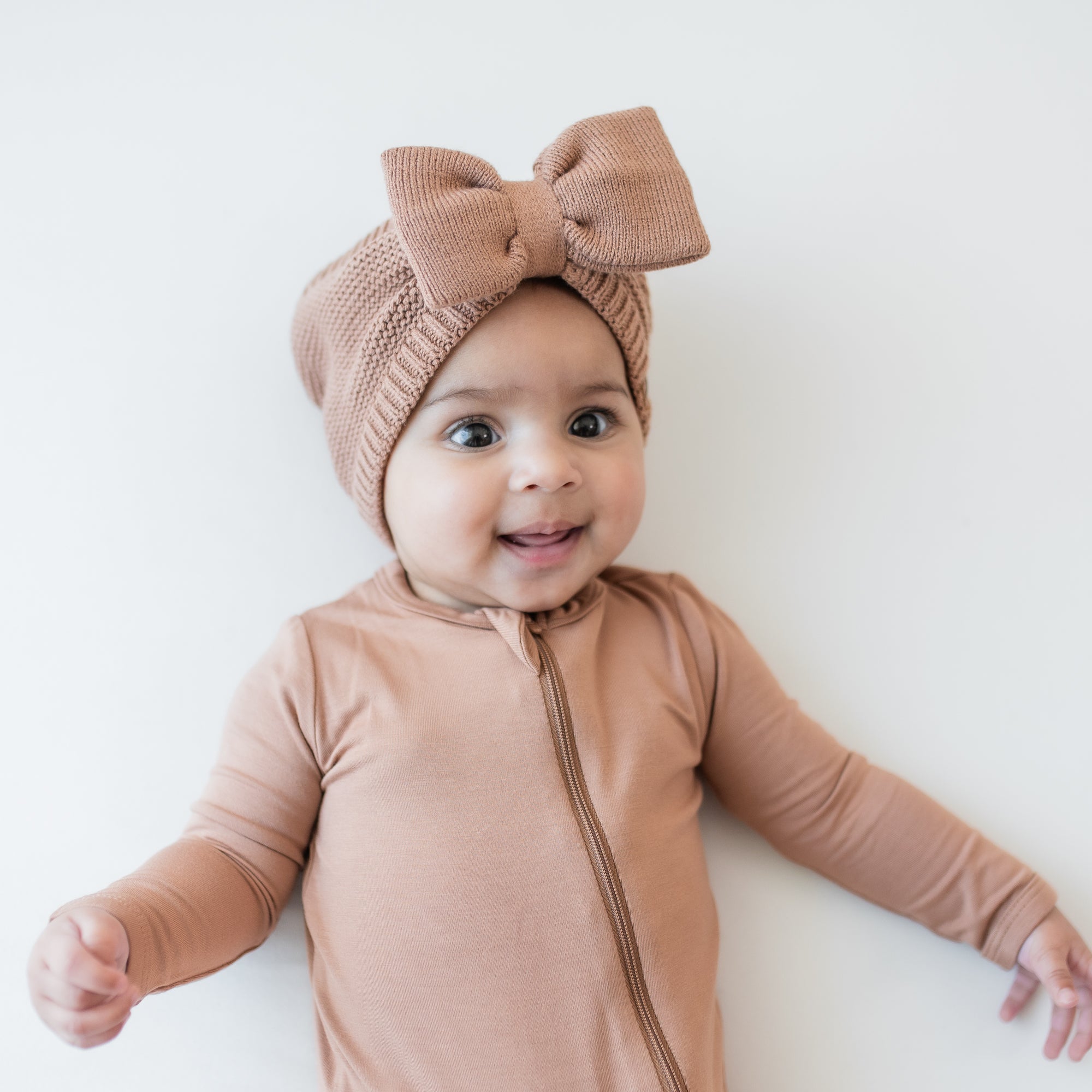 Chunky Knit Bow Headband in Latte shown on a smiling infant