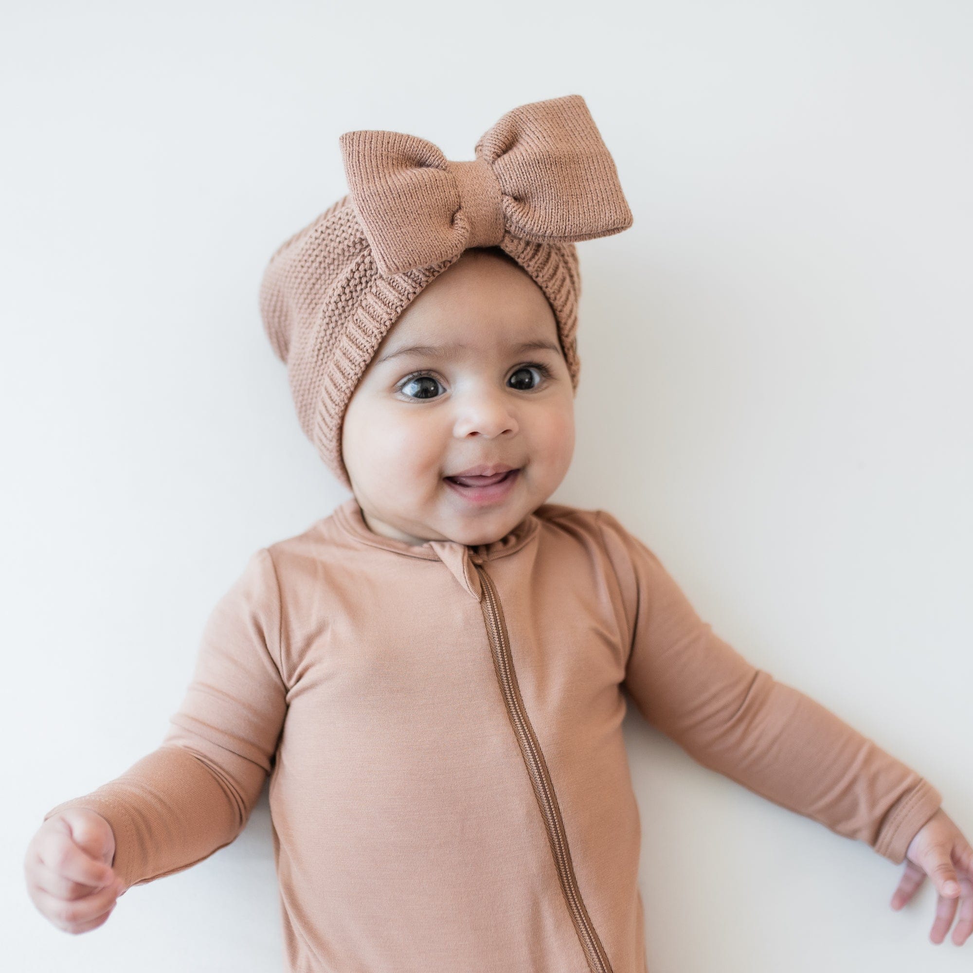 Chunky Knit Bow Headband in Latte shown on a smiling infant