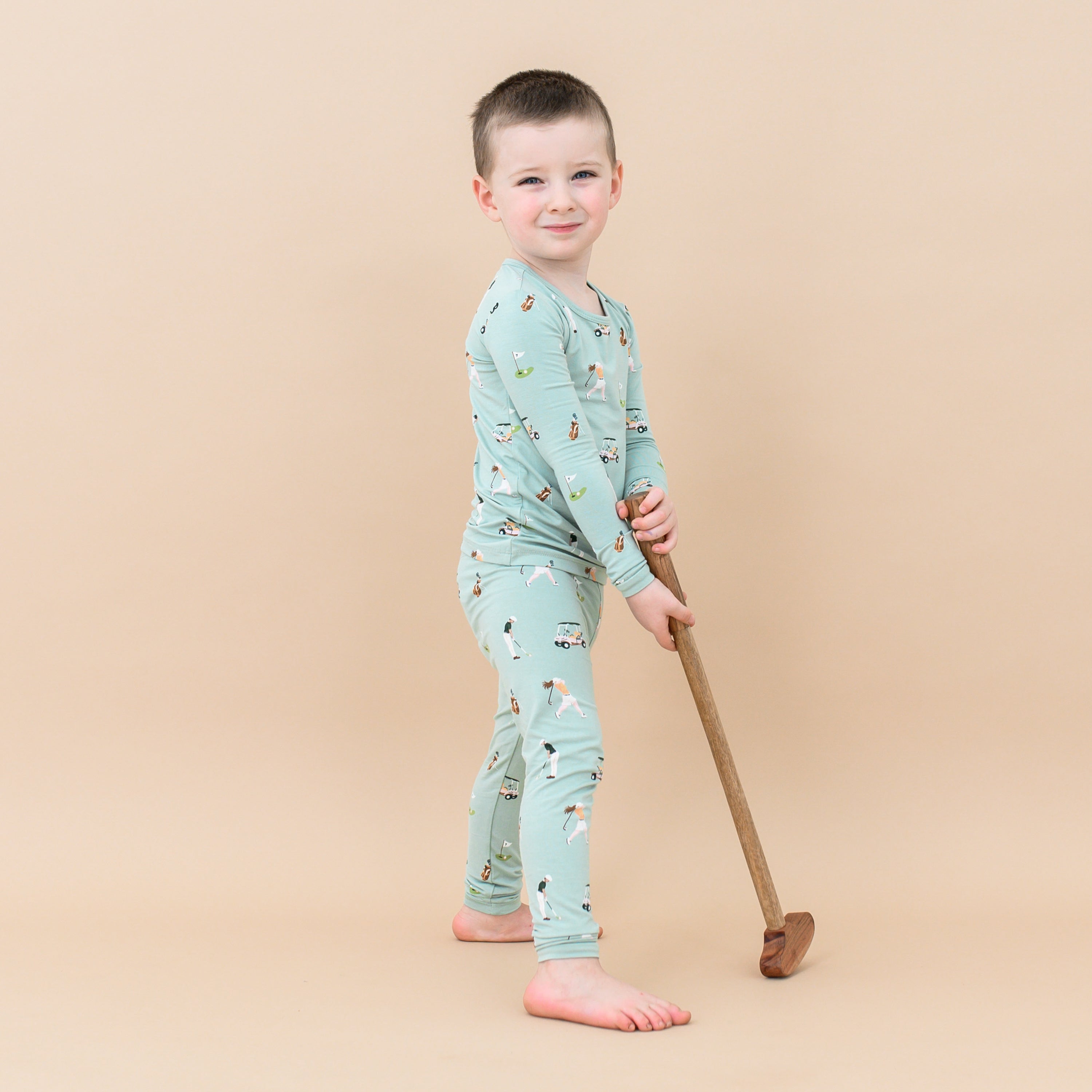 Toddler wearing blue-green Long Sleeve kids Pajamas in Golf print