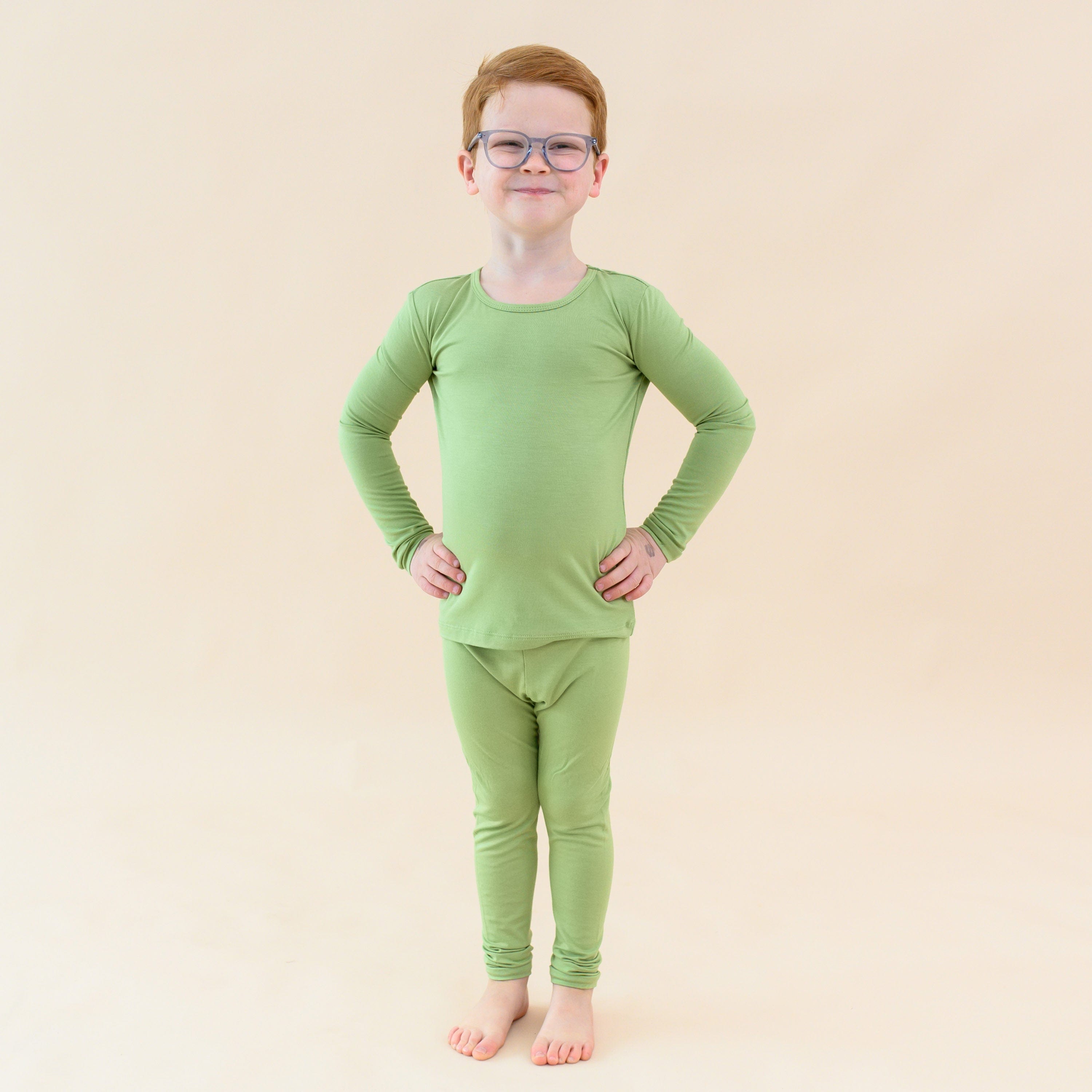 Child wearing long sleeve green pajamas in honu
