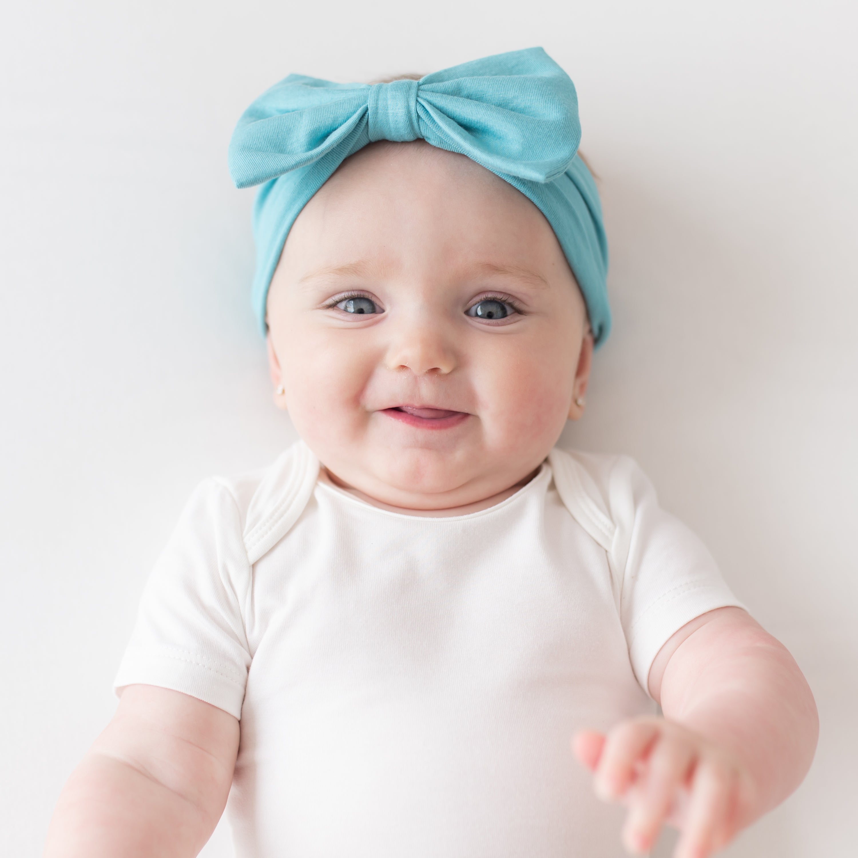 Baby wearing Bow Headband in Makai