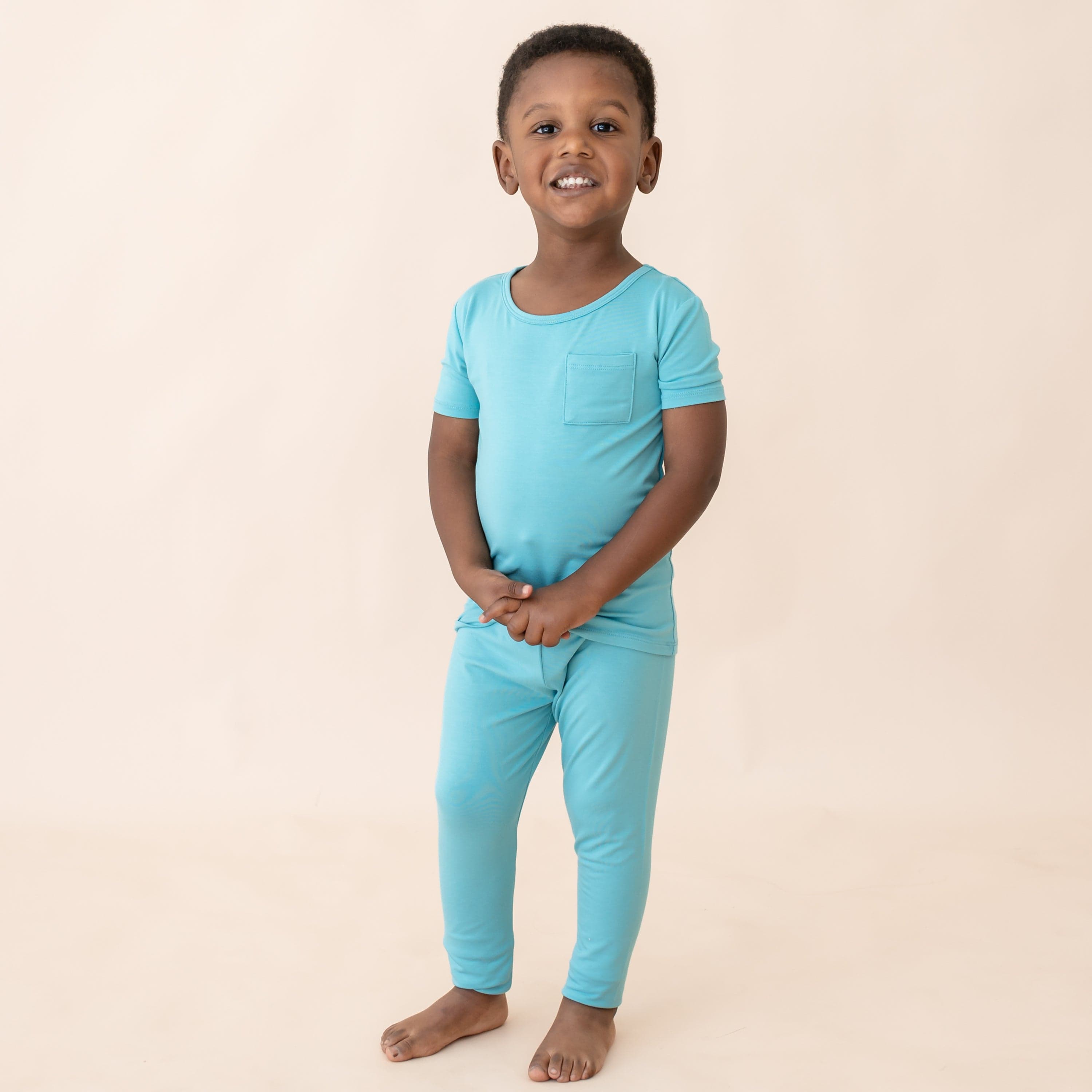 Child wearing Short Sleeve Blue Pajamas with Pants in Makai