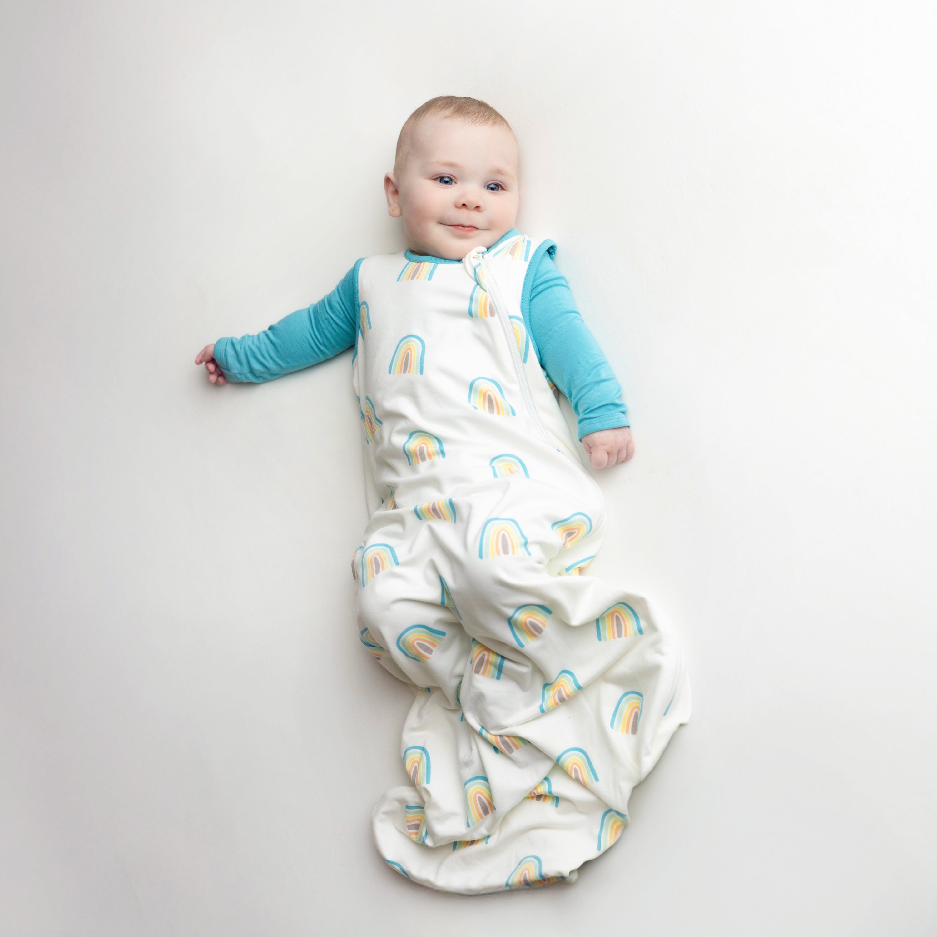 Baby modeling the Sleep Bag in Makai Rainbow 0.5 with a Makai Romper underneath