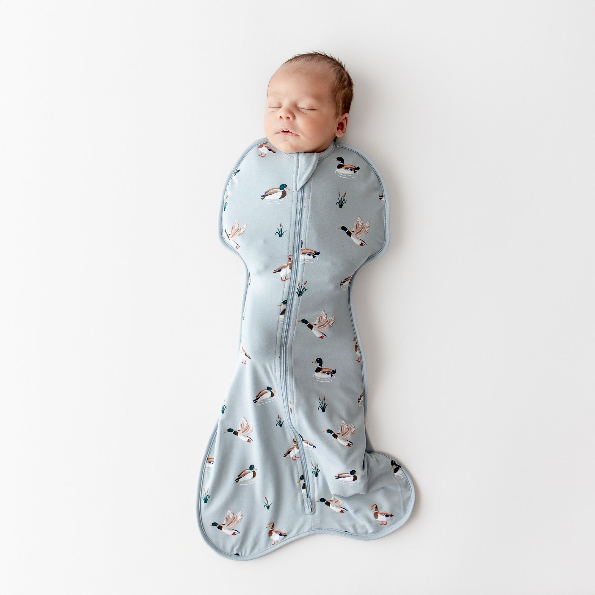 Sleeping newborn wearing the Swaddle Bag in Mallard Duck 0.5