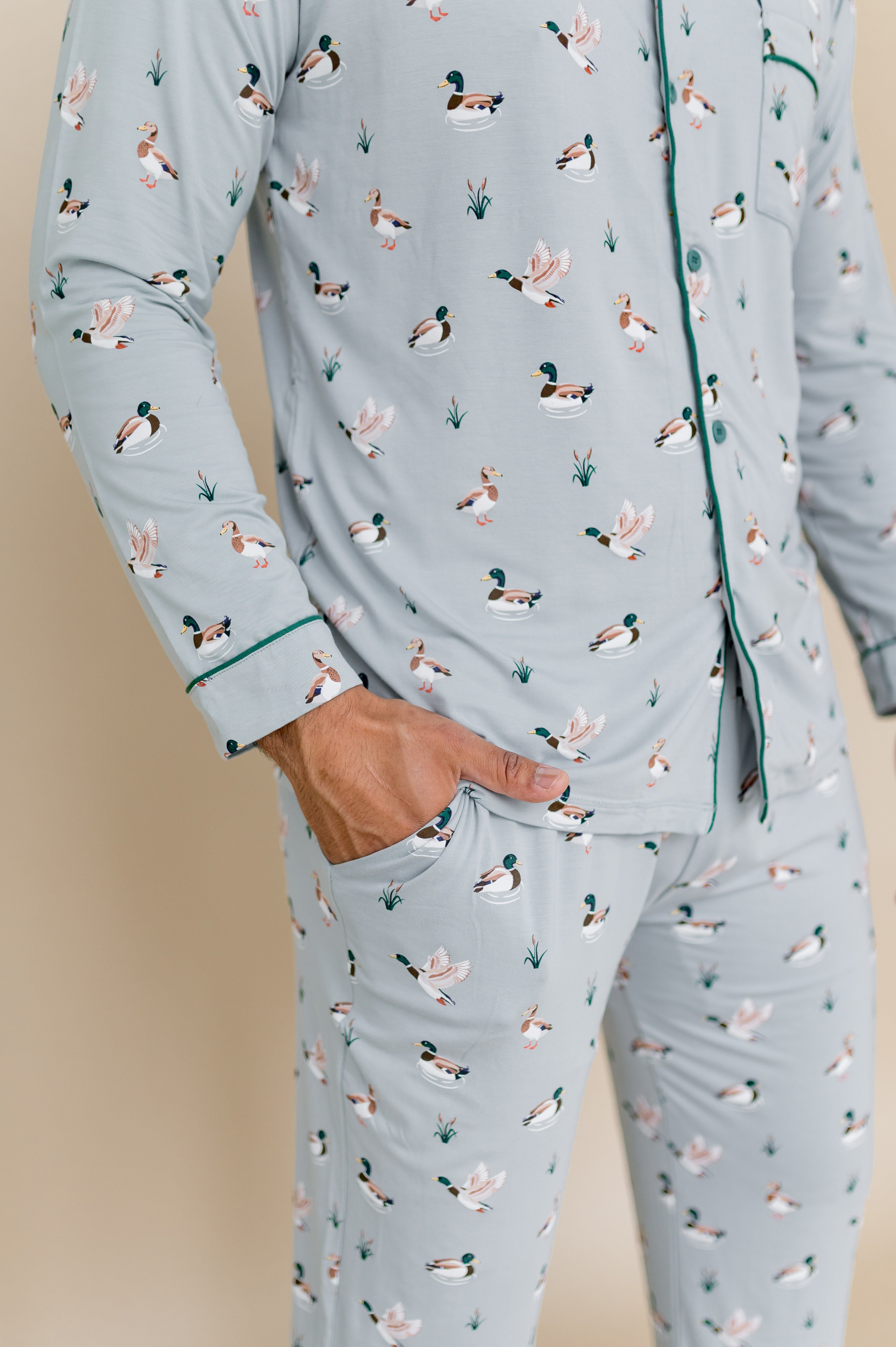 Close up of the green colored trim at at the wrist of the shirt and pocket detail in the pants on the Men's Long Sleeve Pajama Set in Mallard Duck