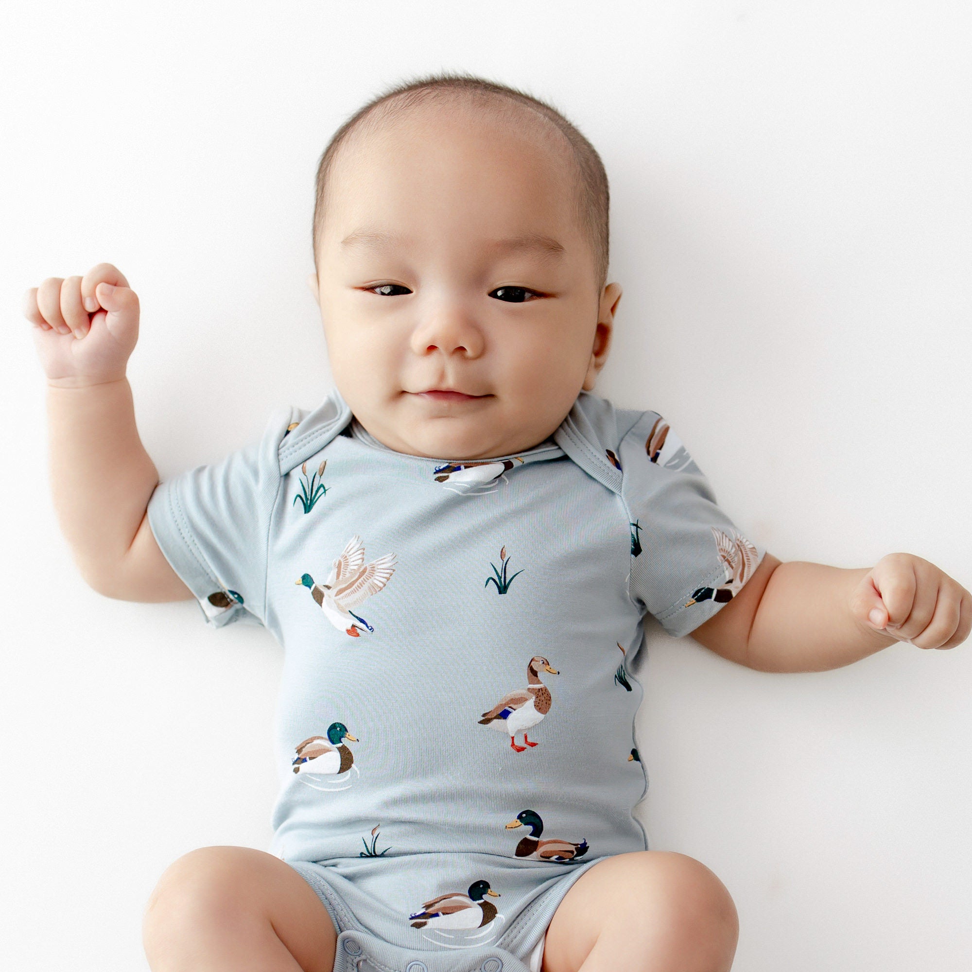 Close up of an infant wearing the Bodysuit in Mallard Duck
