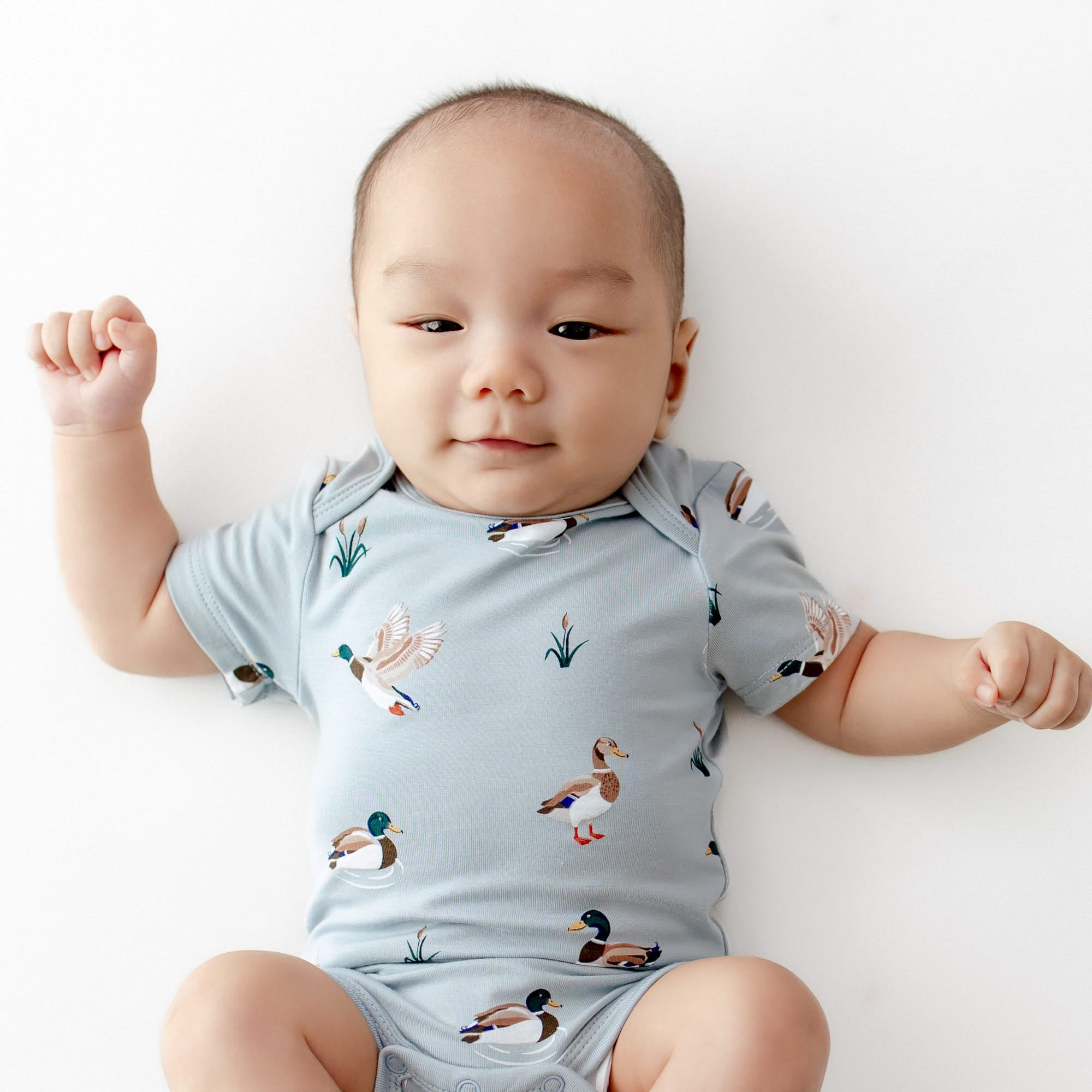 Close up of an infant wearing the Bodysuit in Mallard Duck