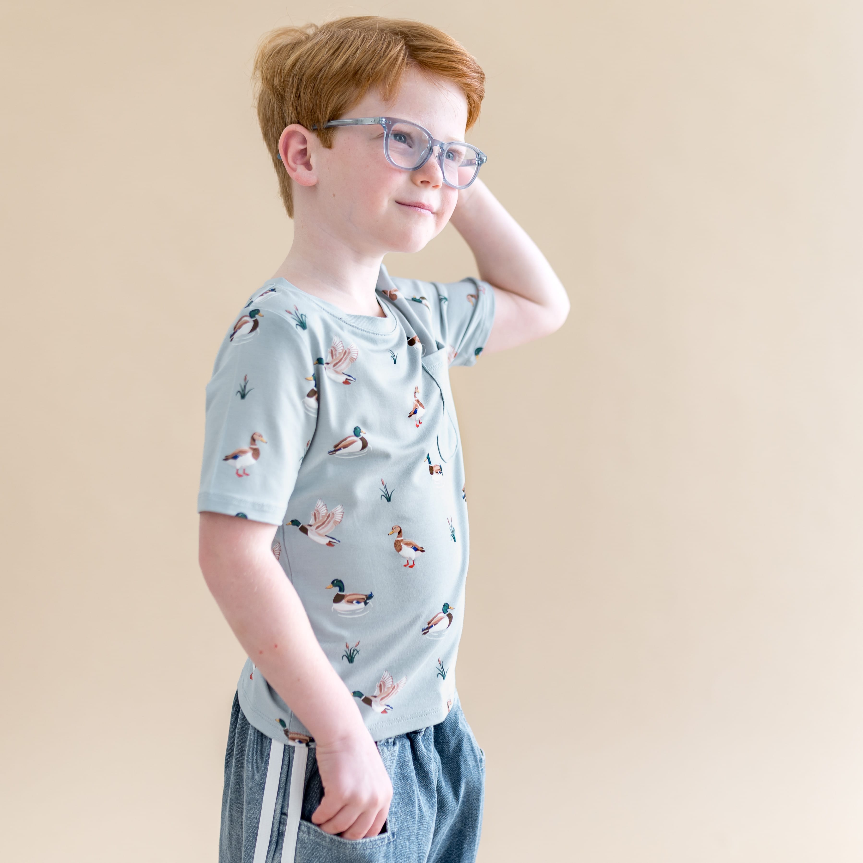 Boy posing looking off to the side wearing the Toddler Crew Neck Tee in Mallard Duck
