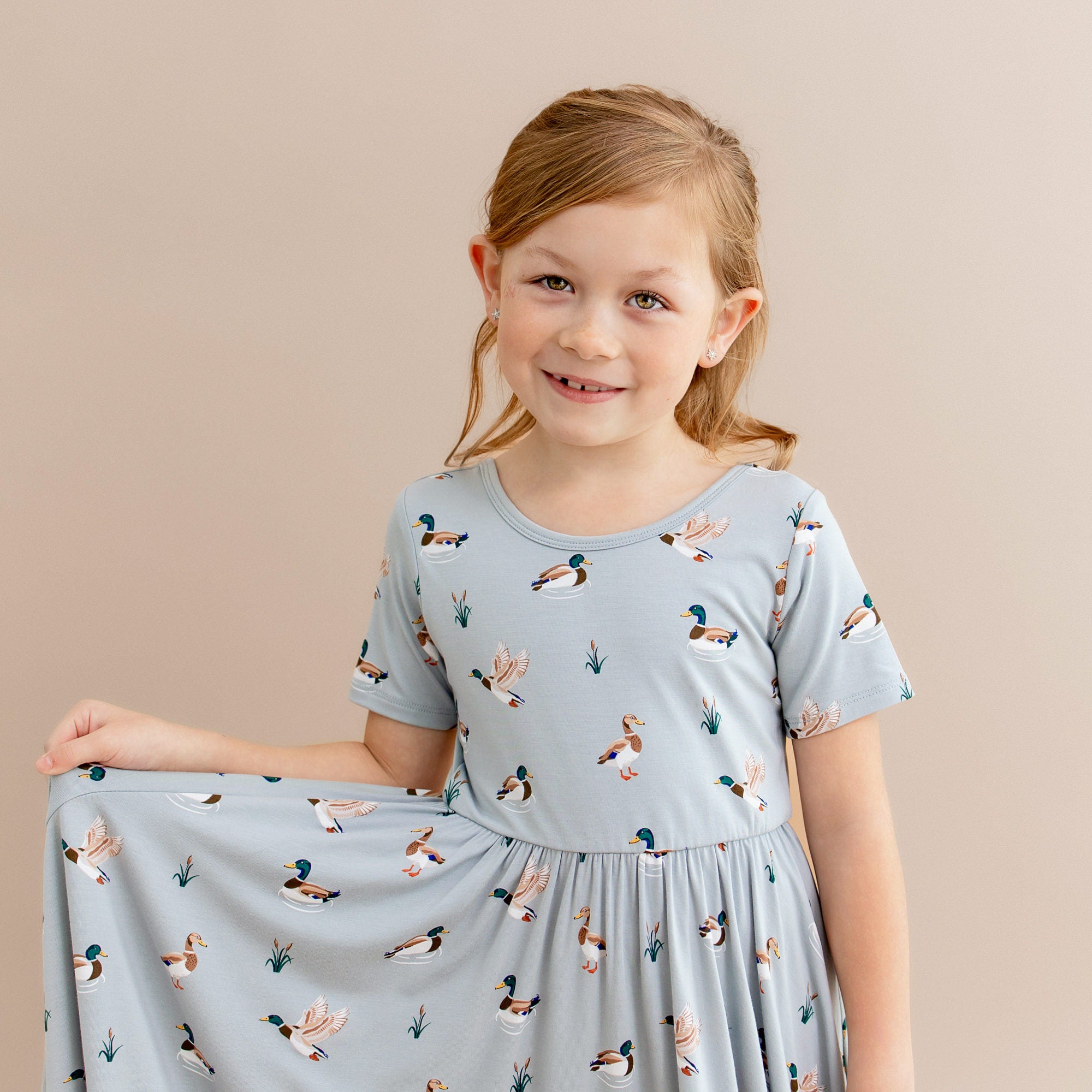 Close up of young girl modeling the Twirl Dress in Mallard Duck