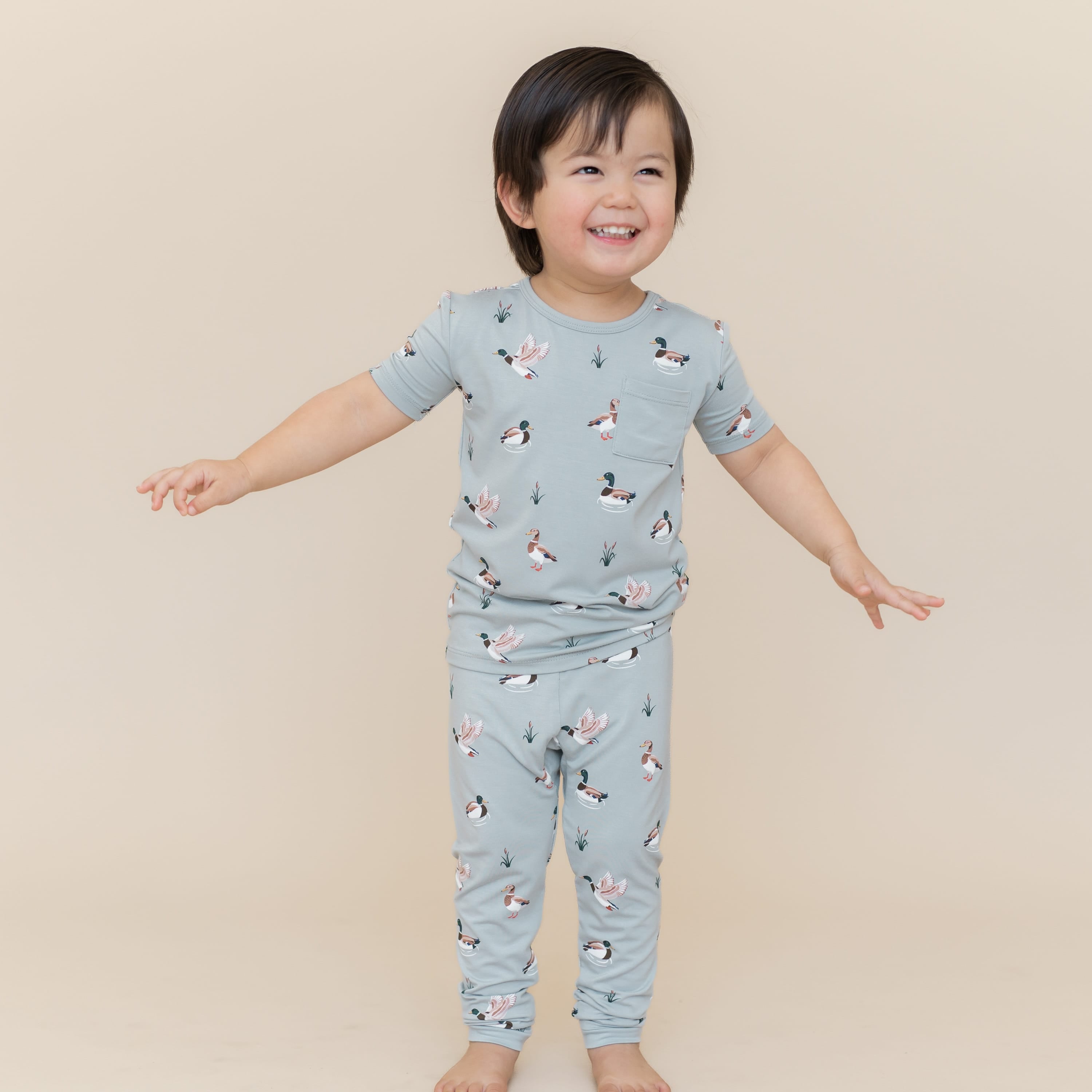 Young smiling boy posing wearing the Short Sleeve with Pants Pajamas in Mallard Duck