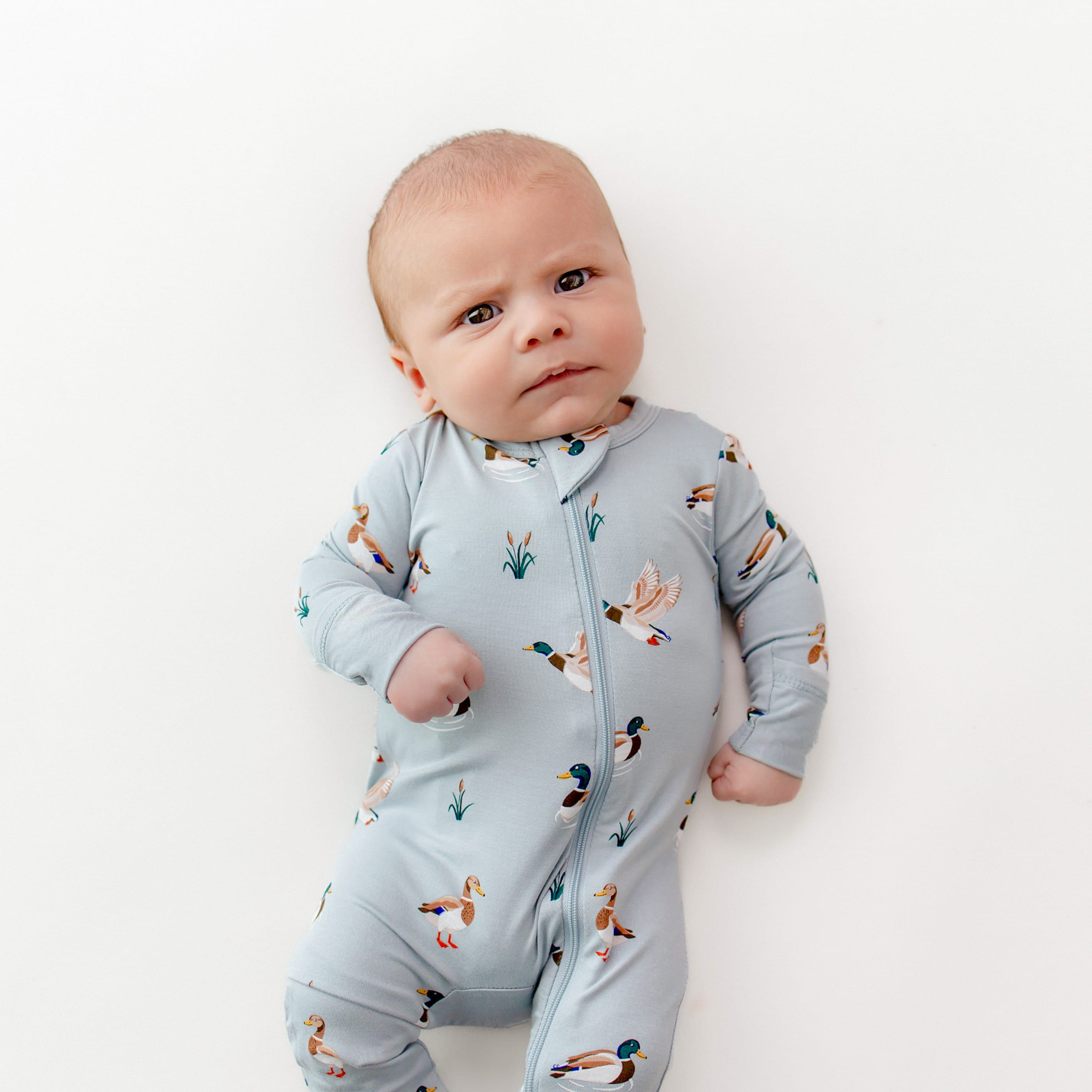 Close up of the Zippered Romper in Mallard Duck shown on an infant
