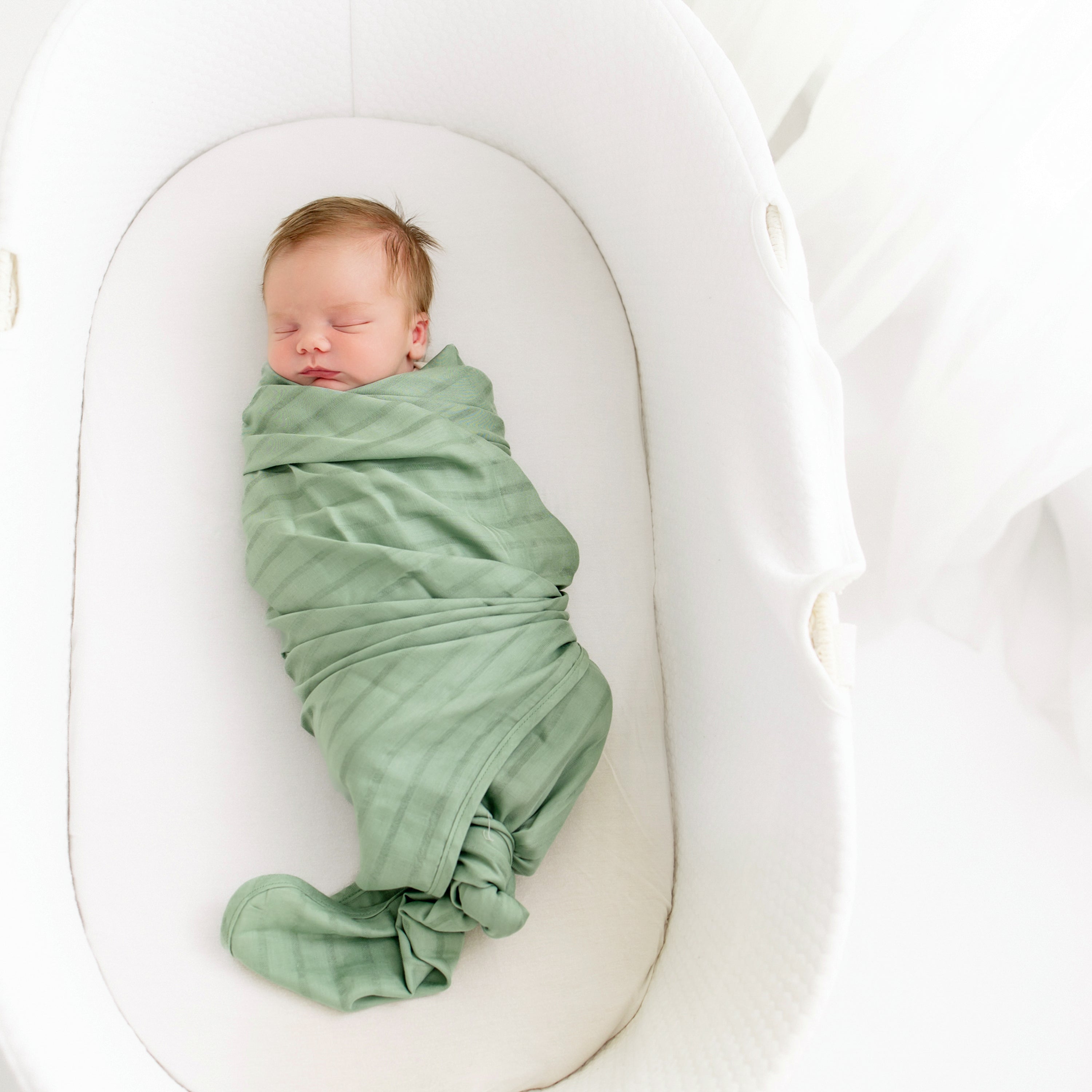 Newborn wrapped in Bamboo Muslin Swaddler Blanket in Matcha Green