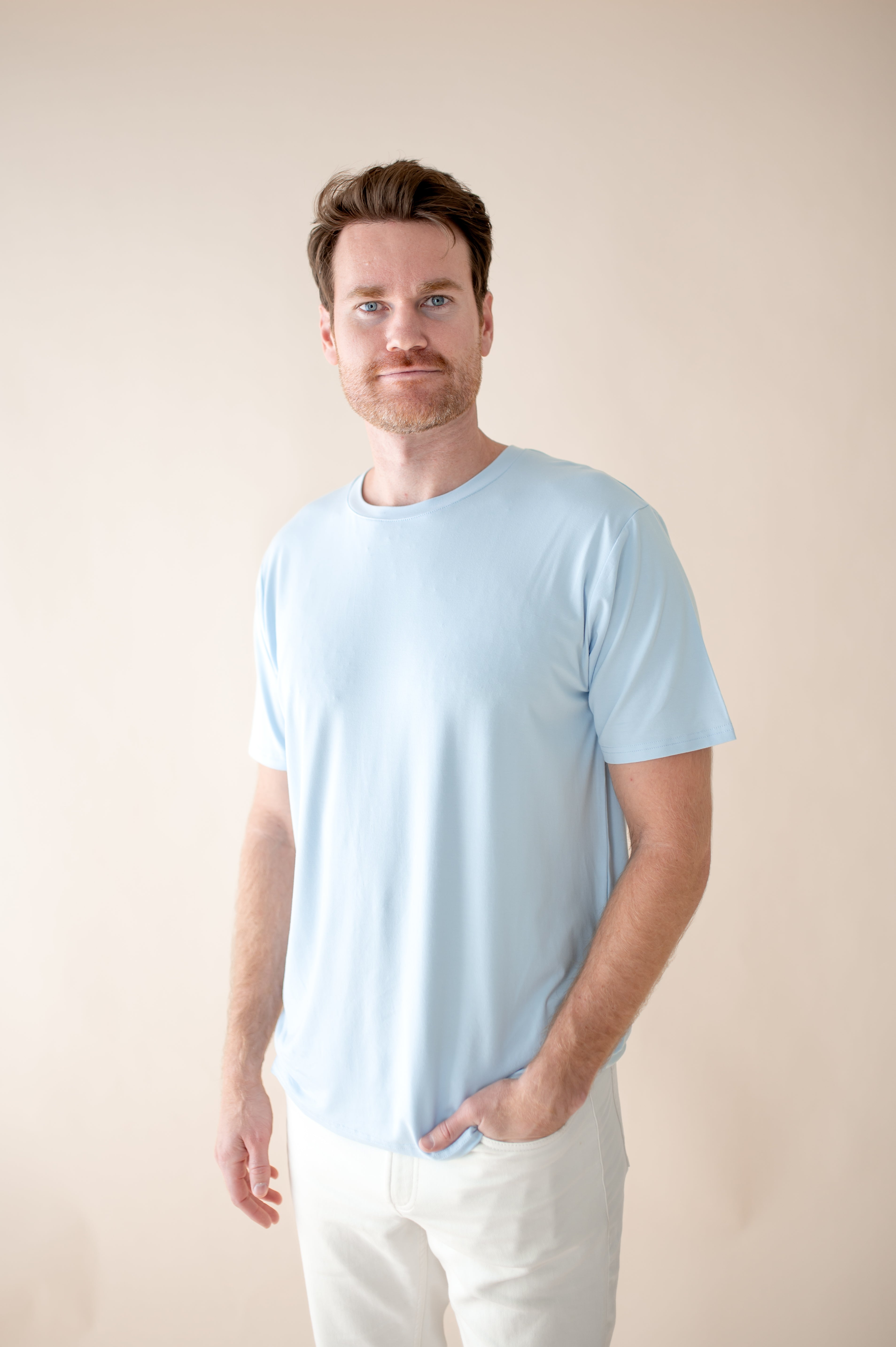 Male modeling the Men's Crew Neck Tee in Breeze in front of a light neutral background