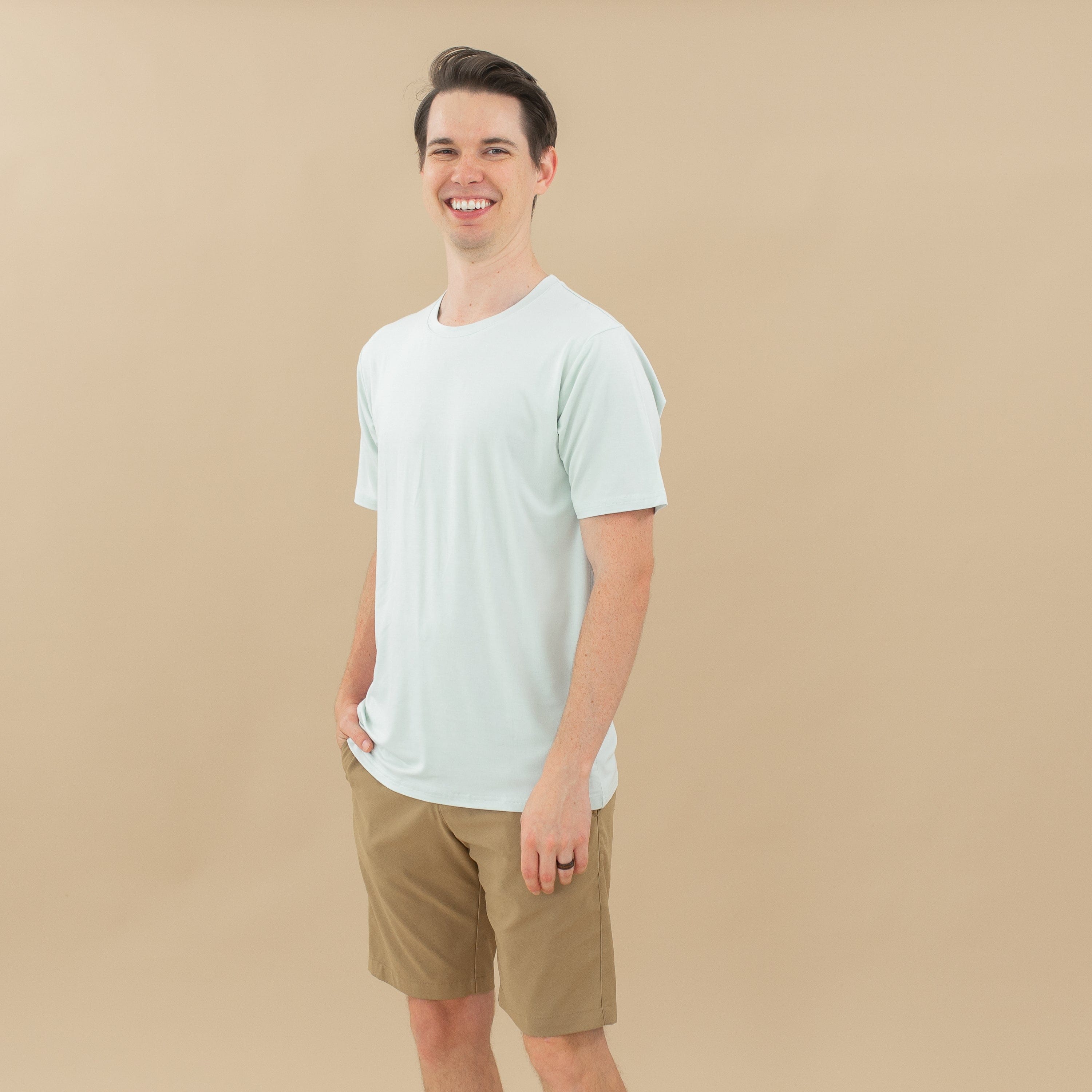 Male model wearing the Men's Crew Neck Tee in Dew paired with tan shorts