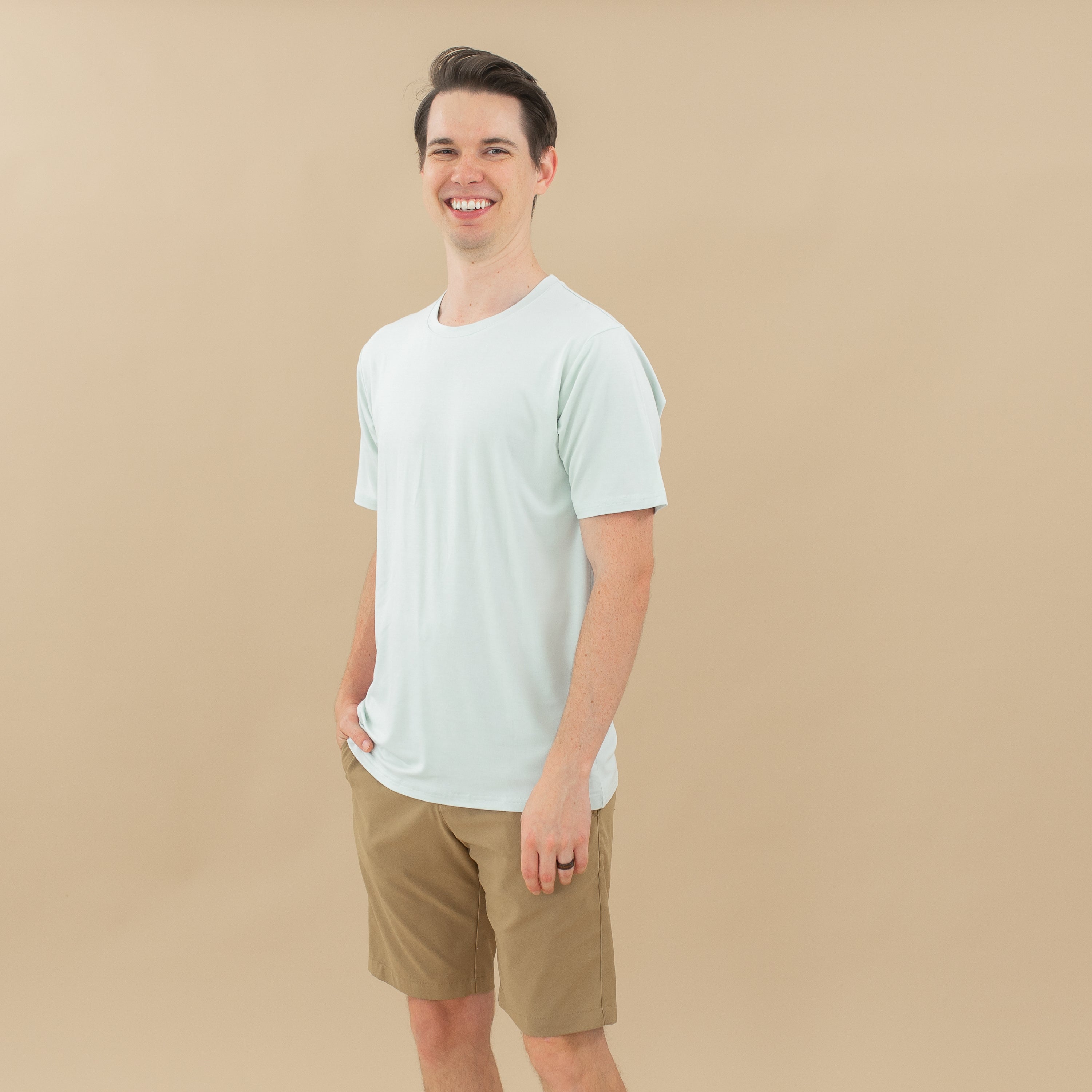 Male model wearing the Men's Crew Neck Tee in Dew paired with tan shorts